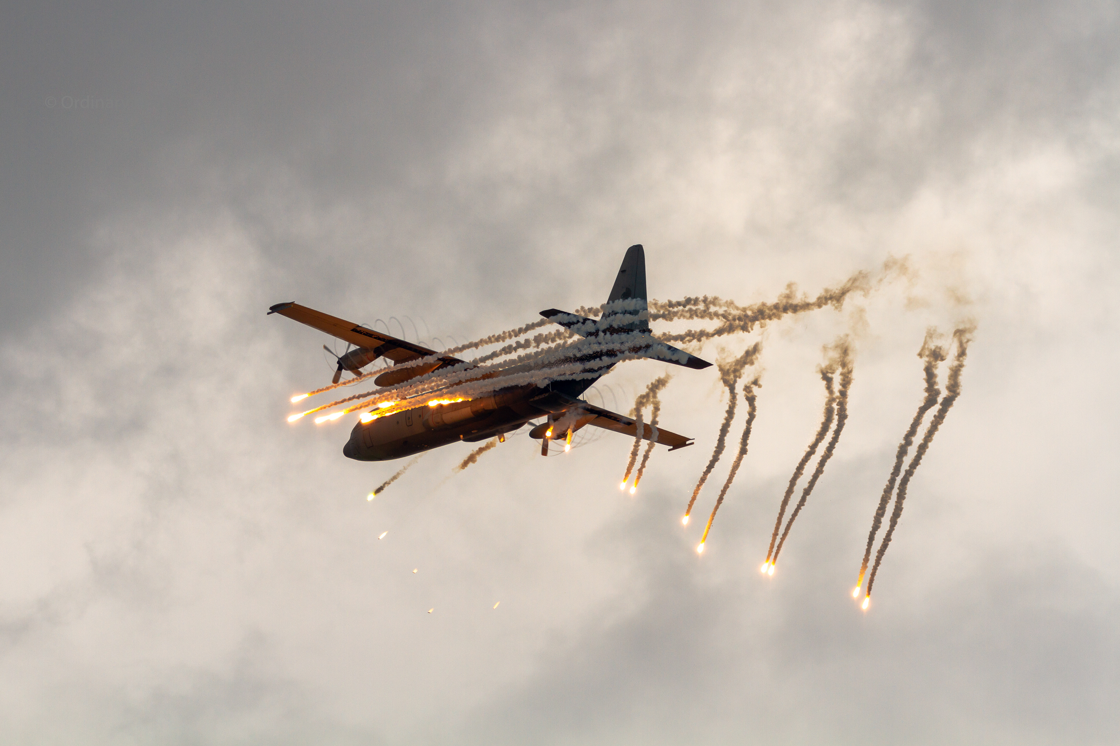 A C-130 Hercules transport plane releasing flares during the Luchtmachtdagen 2019 at Vliegbasis Volkel