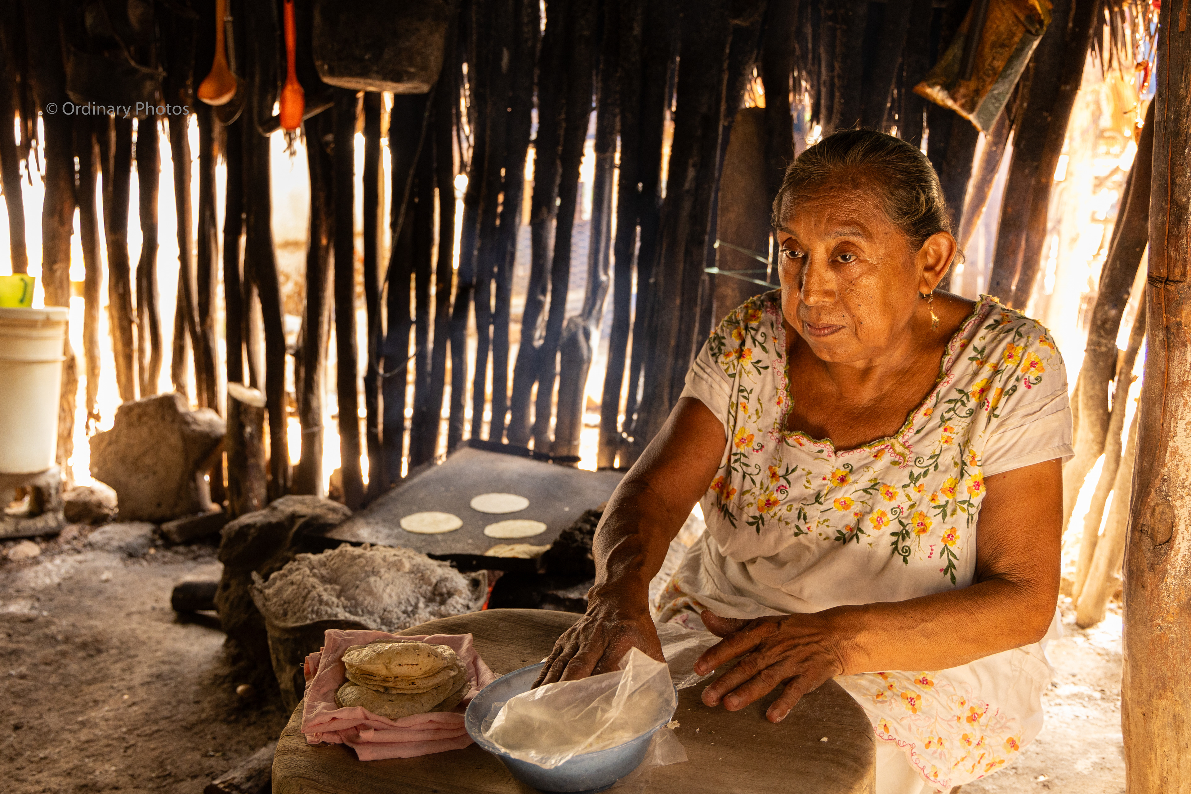 An older woman making tortillas in a Maya village