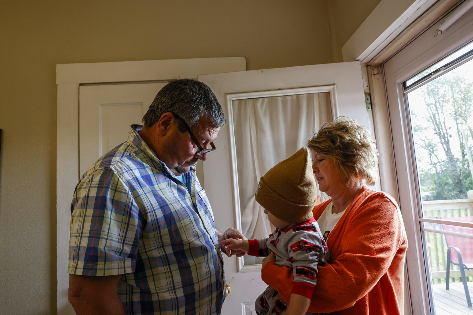 At noon each day Jason goes home for a midday meal with his entire family. In the arms of his grandmother, Melissa Gifford, 11-month-old Jase Massey plays with the buttons on his grandfather’s shirt. This time of day is important to Jason and a needed break from work.