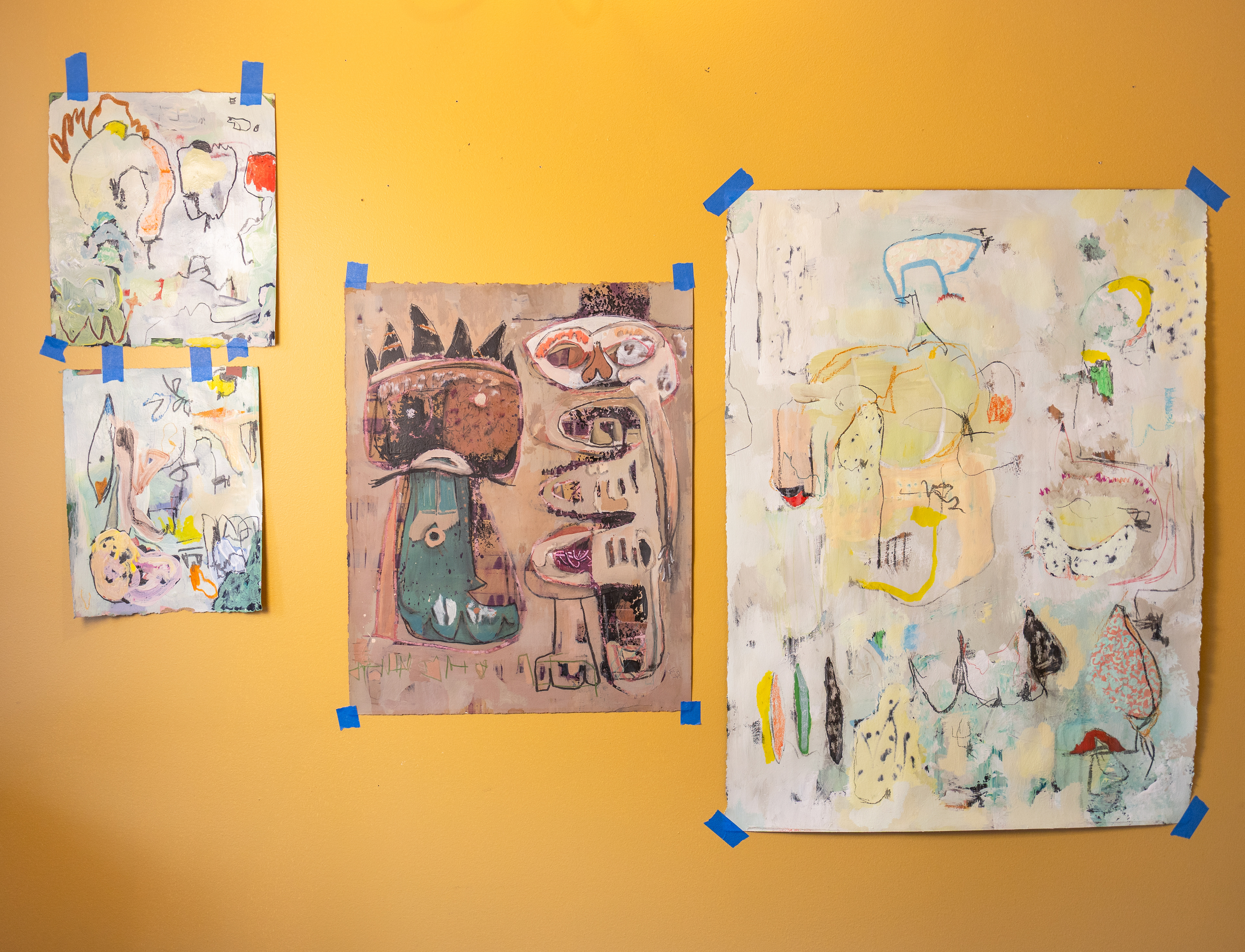 A collection of Shropshire’s mixed media paintings taped to the wall of his studio.