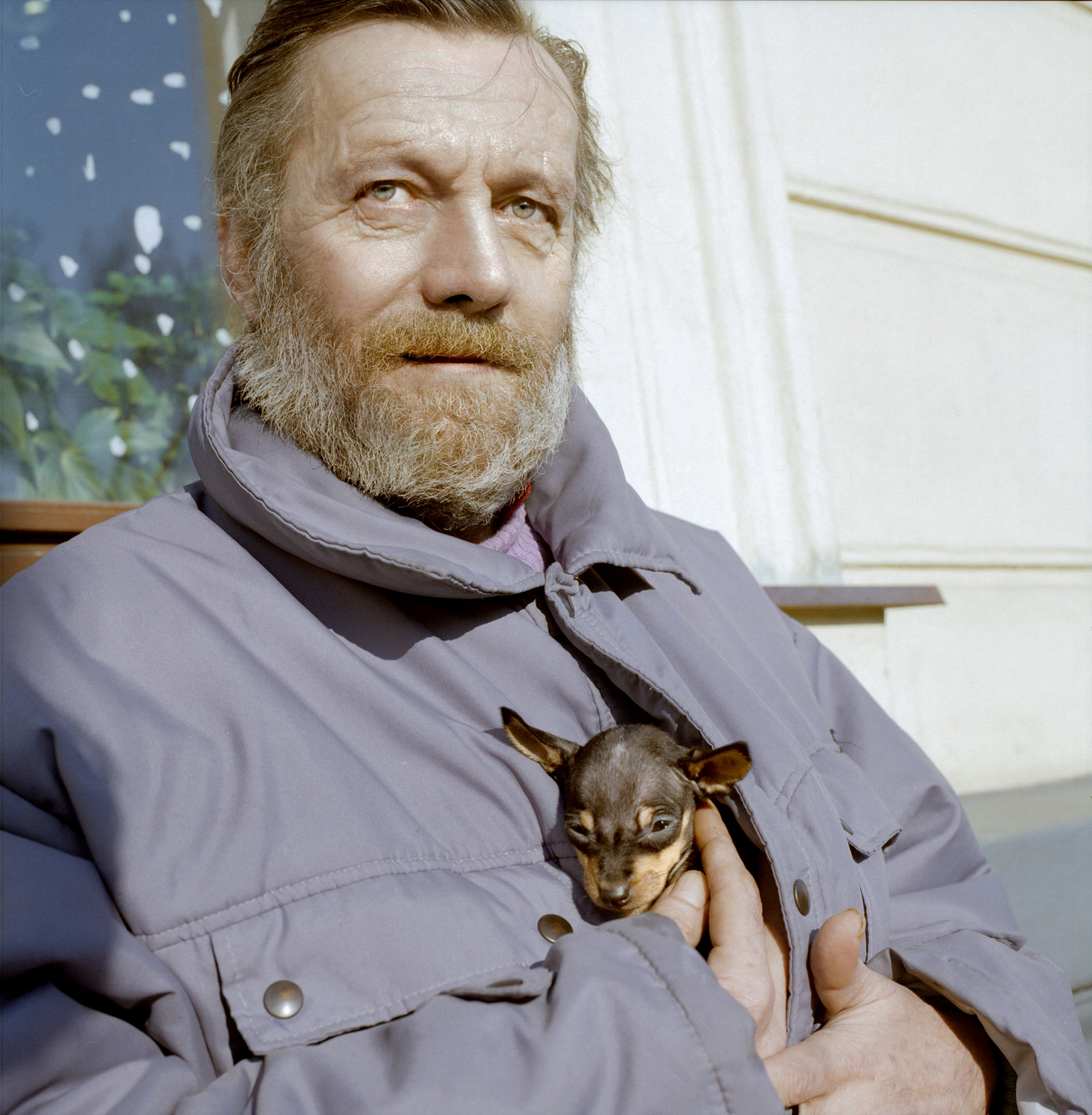 prag analog mann wärmt 2 kleine hunde am körper