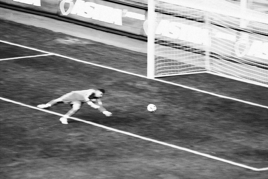 torwart springt zum ball vor einem tor. unscharf