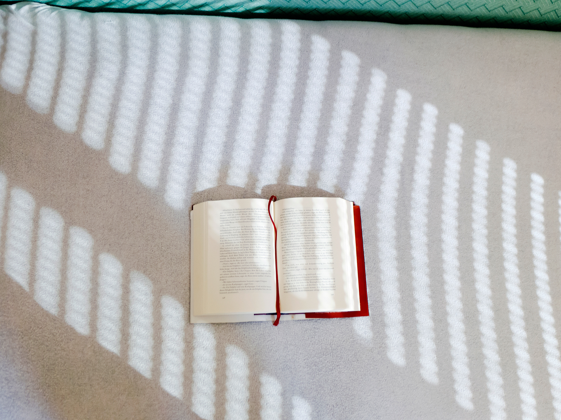 aufgeschlagenes buch auf bett. minimalistisch