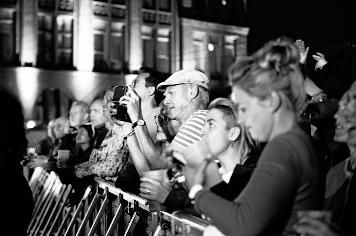 bw photo. concert audience, a man is taking a picture