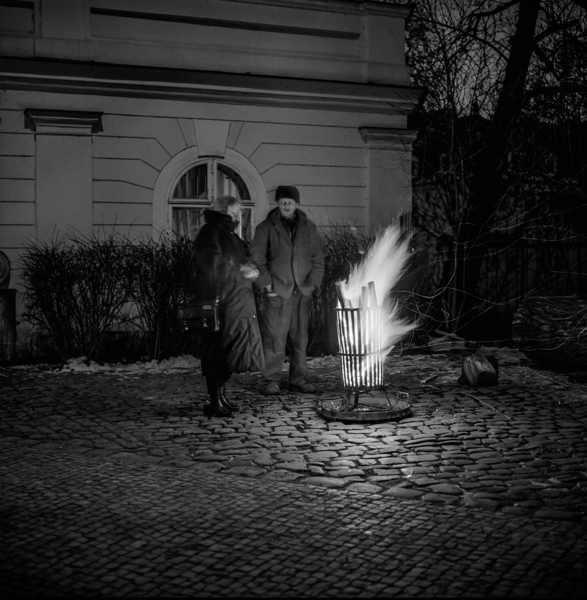 prag analog nachtaufnahme 2 menschen stehen an einem feuer