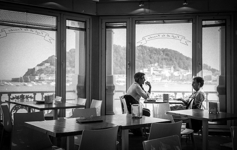 Two friends have breakfast watching the beach of "La Concha"