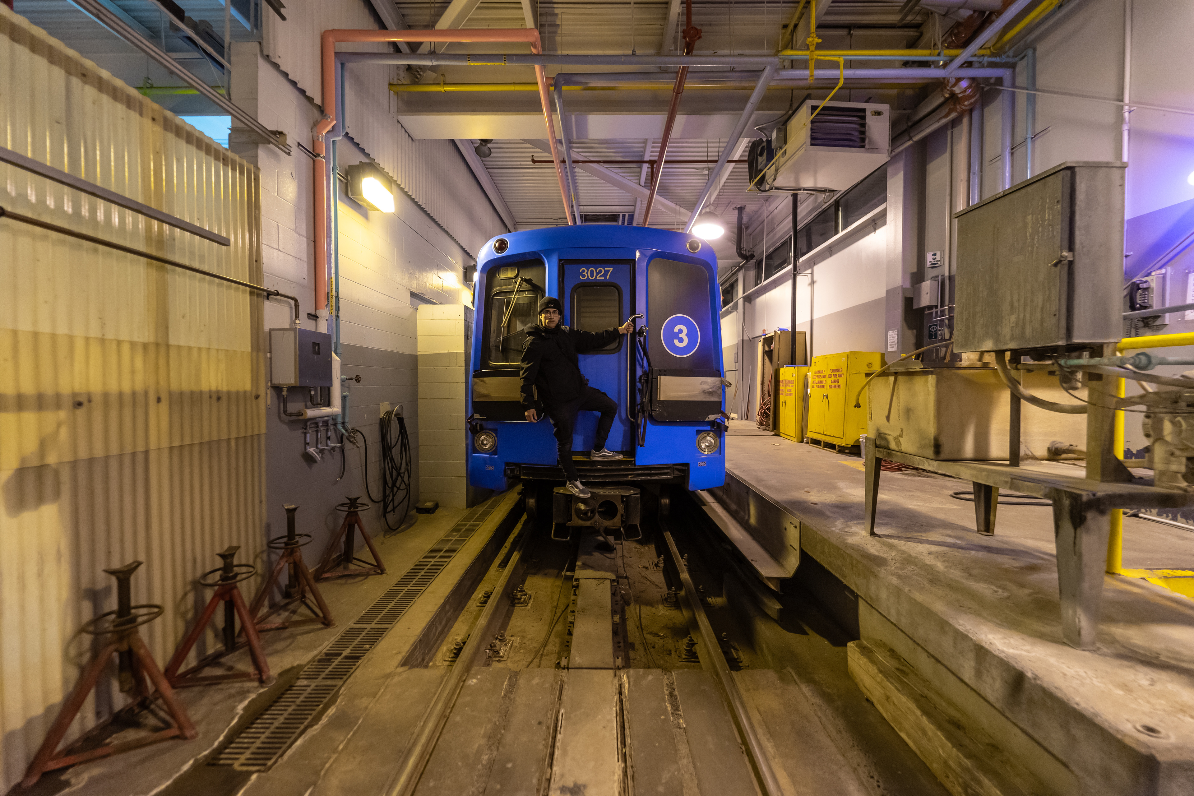 Posing for a photo in a Toronto Transit Maintenance Facility, with train cars that were decommissioned.