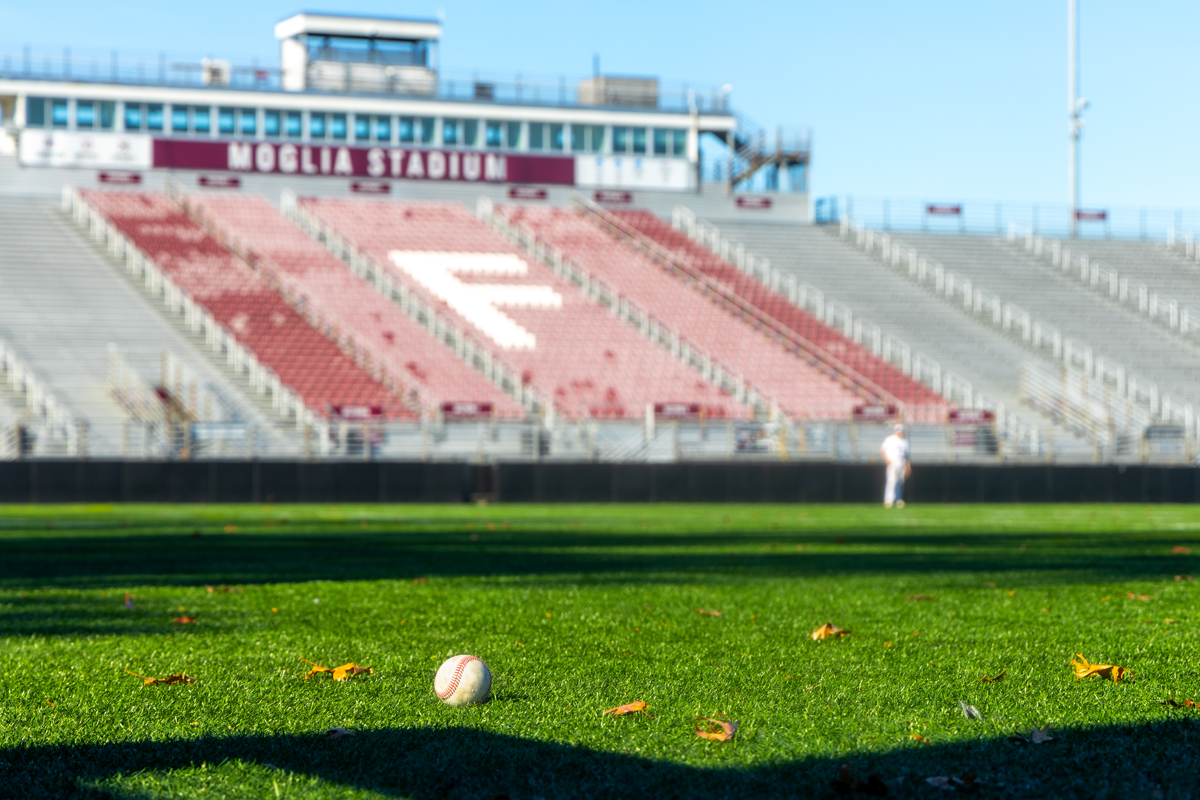 A baseball lays on the infield.