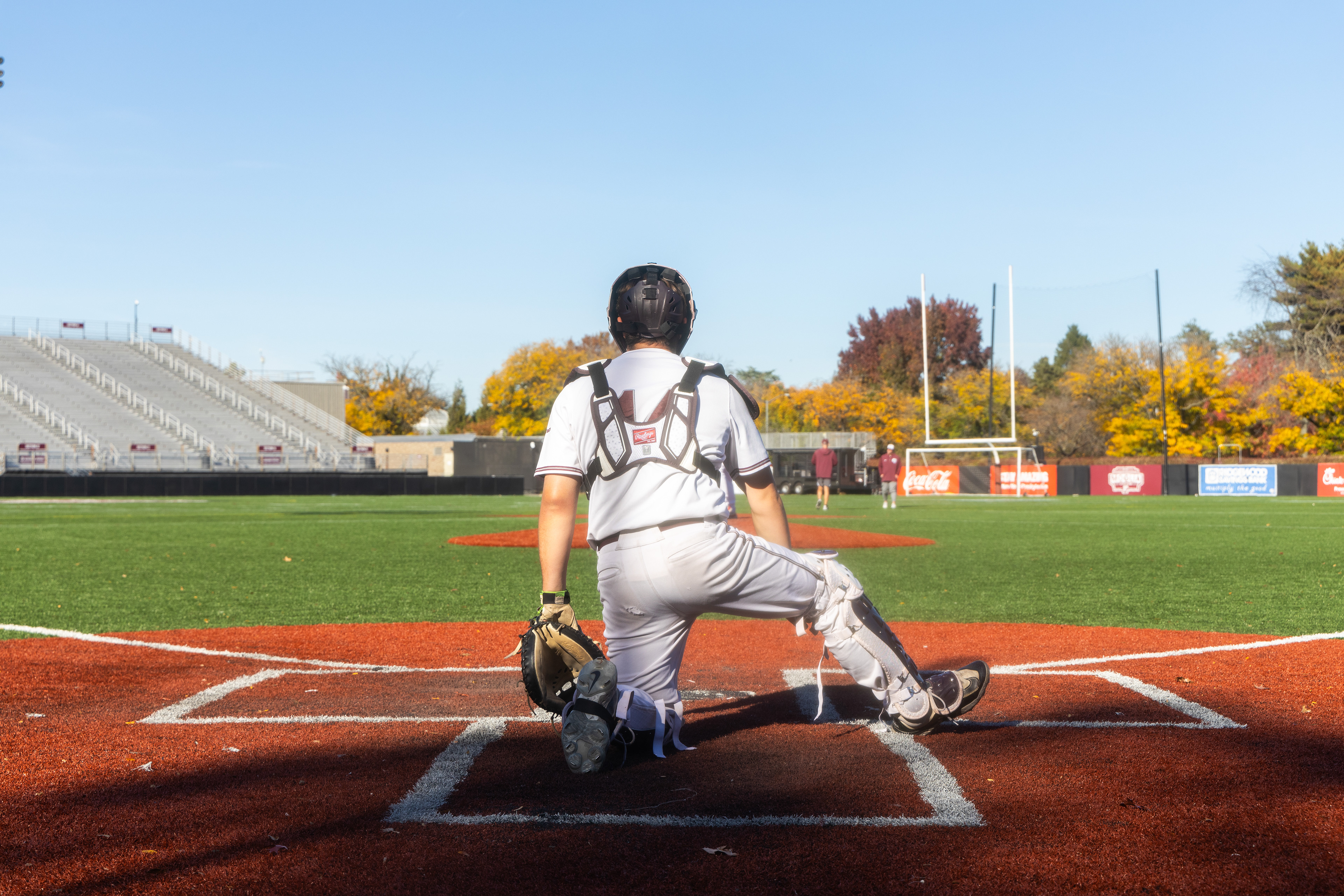 A catcher waiting for the pitch in the catcher's box.
