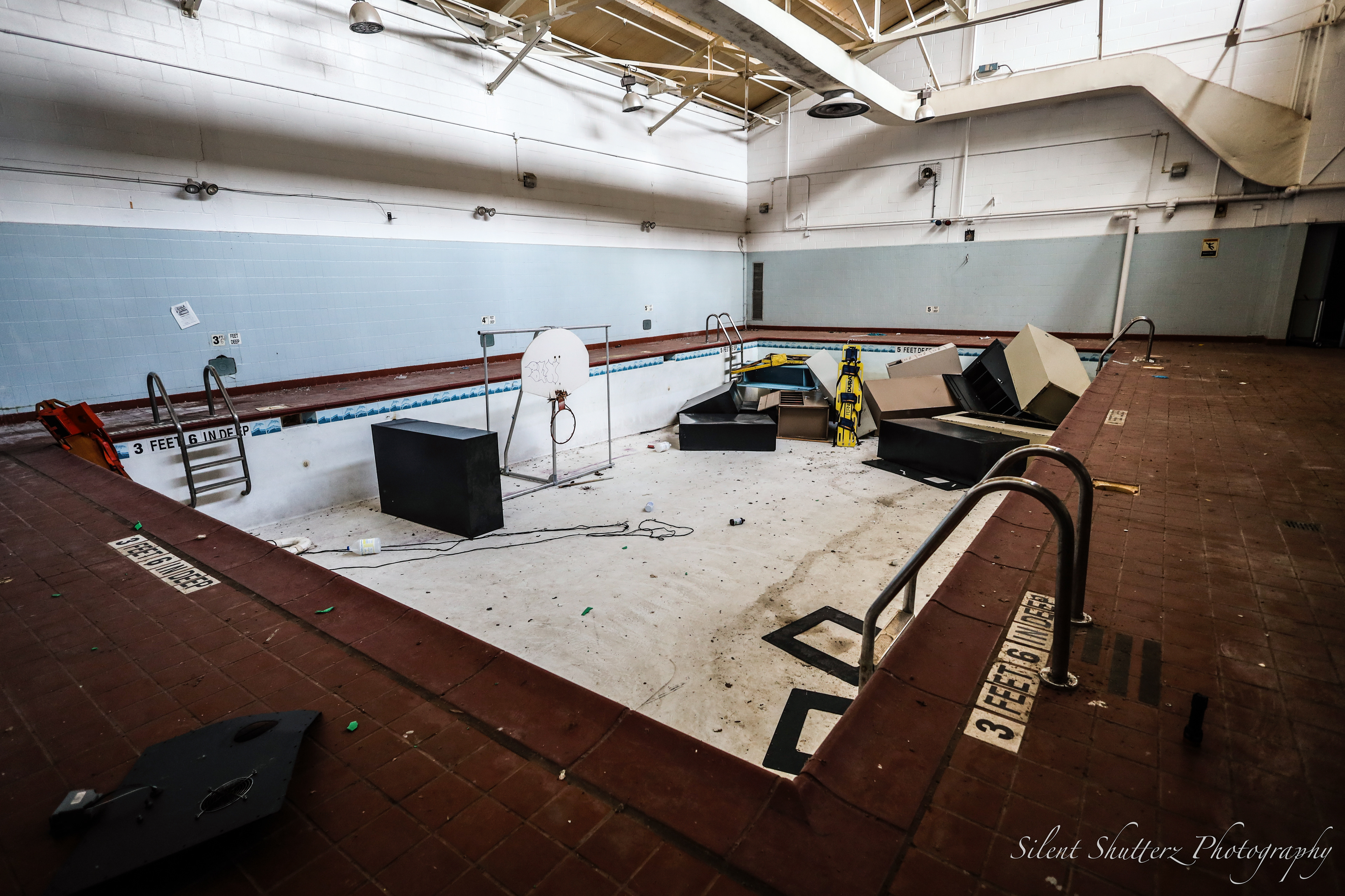 An indoor pool in the children's section, littered with miscellaneous items.