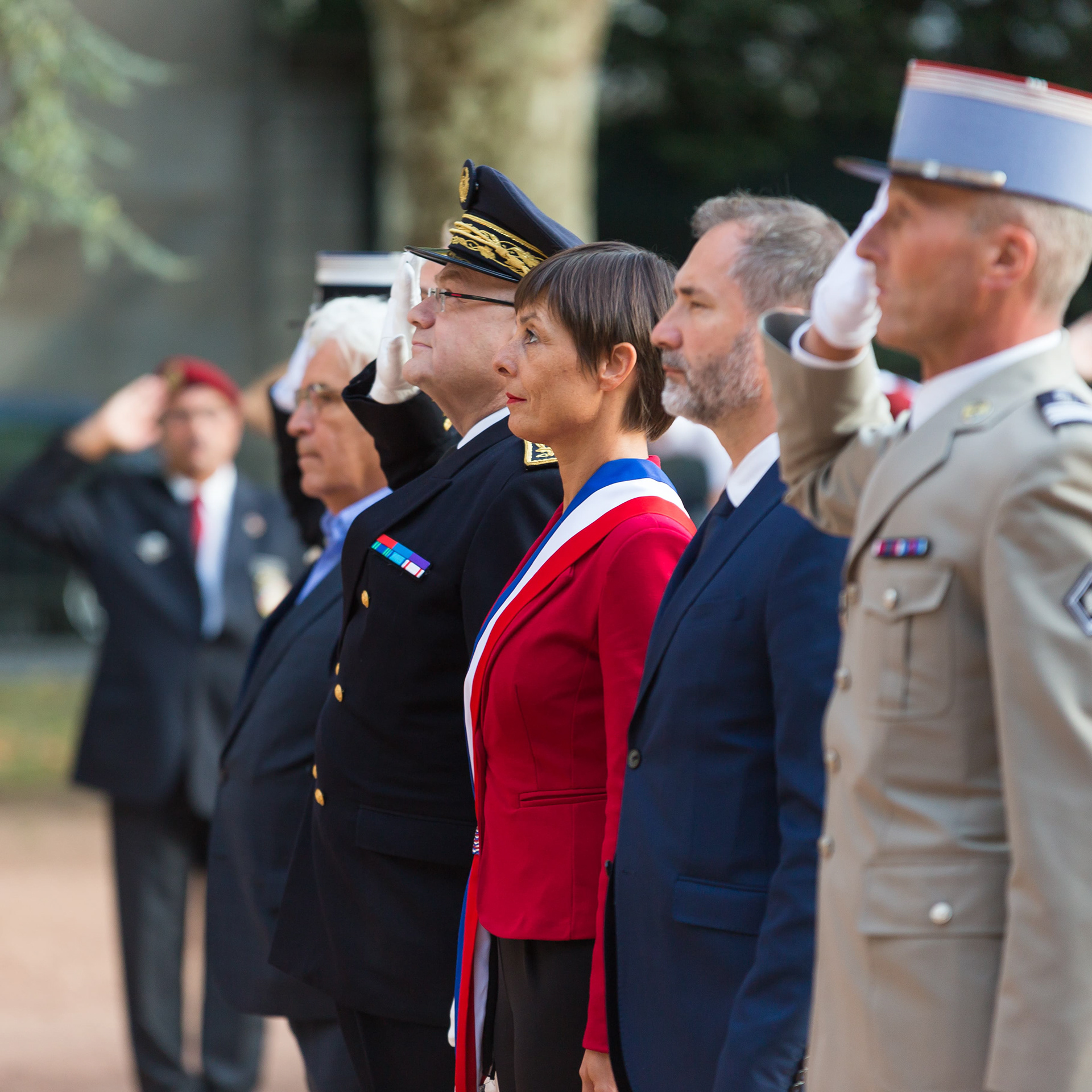 Cérémonie officielle en Saône-et-Loire, Bourgogne, Rhône-Alpes avec des représentants gouvernementaux et militaires en uniforme rendant hommage, photographiée par Etienne Gatheron. On y voit des officiels en tenue formelle et des militaires saluant, marquant un moment de respect et de commémoration.