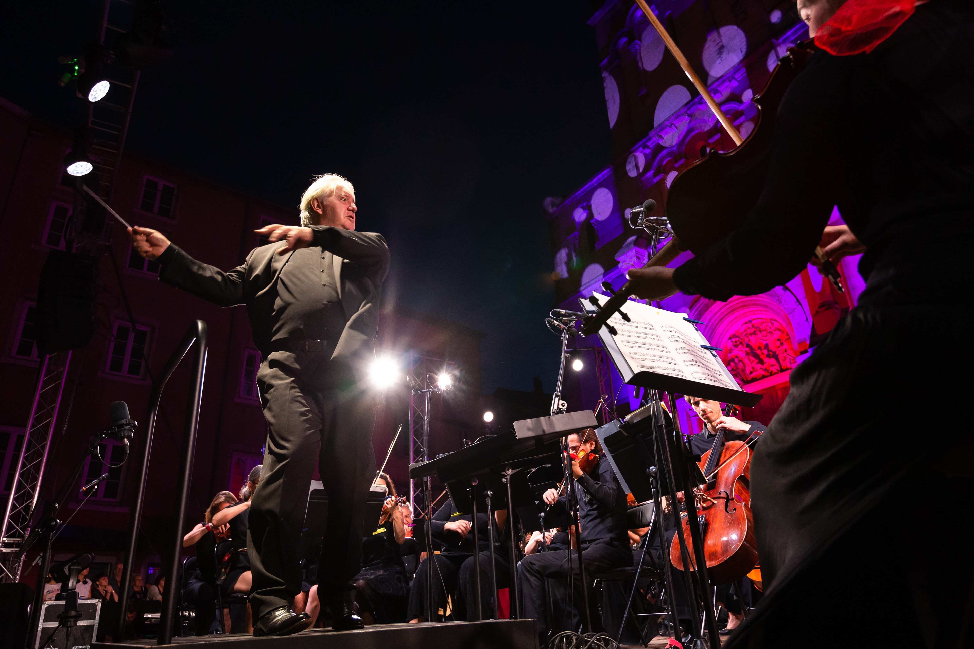 Chef d'orchestre dirigeant un concert en plein air lors d'un événement nocturne à Mâcon, Saône-et-Loire, Bourgogne, Rhône-Alpes. Photographie capturée par Etienne Gatheron. Photographie institutionnelle.
