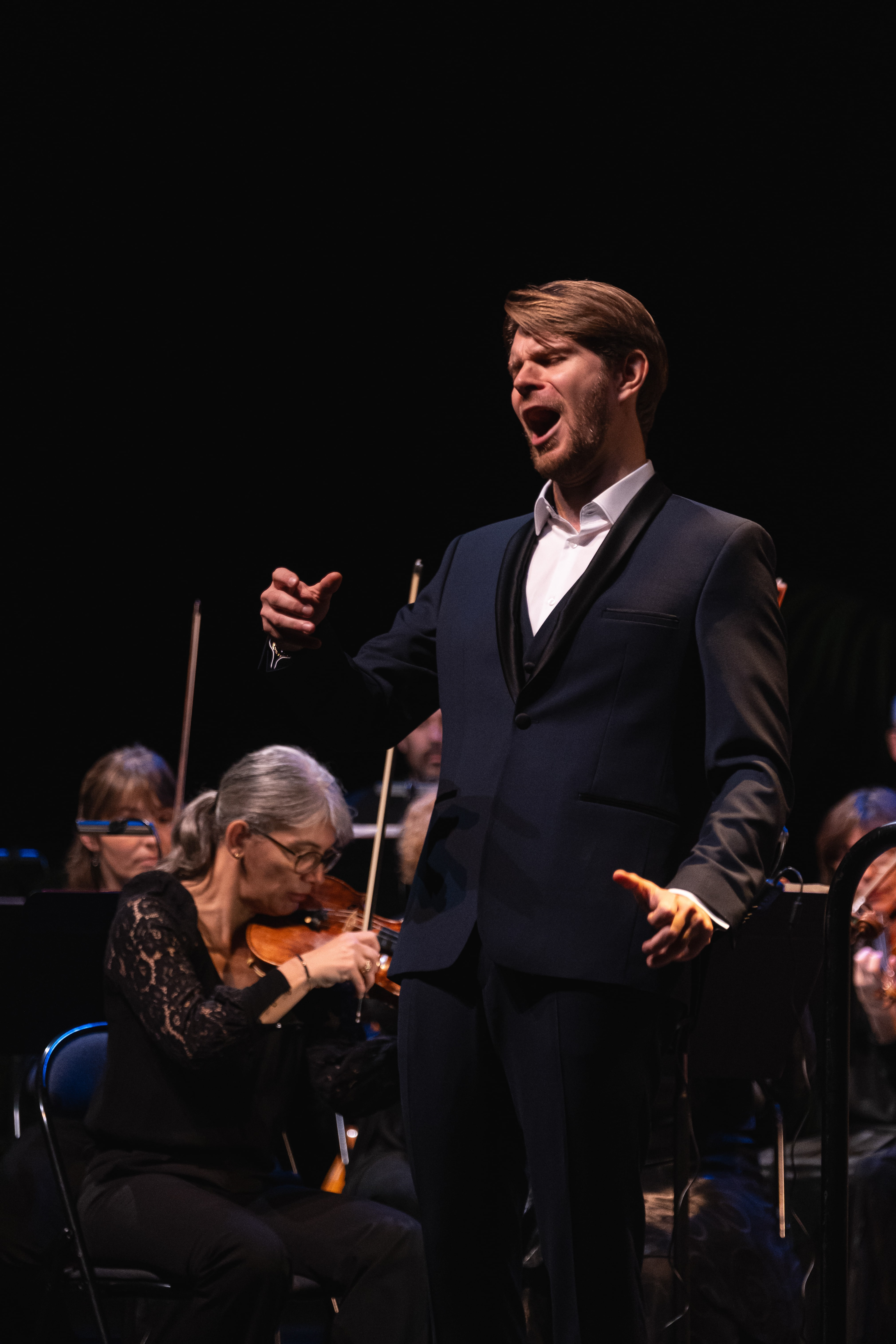 Chanteur d'opéra en pleine performance avec un orchestre en arrière-plan à Mâcon, Saône-et-Loire, Bourgogne, Rhône-Alpes. Photographie capturée par Etienne Gatheron. Photographie institutionnelle.