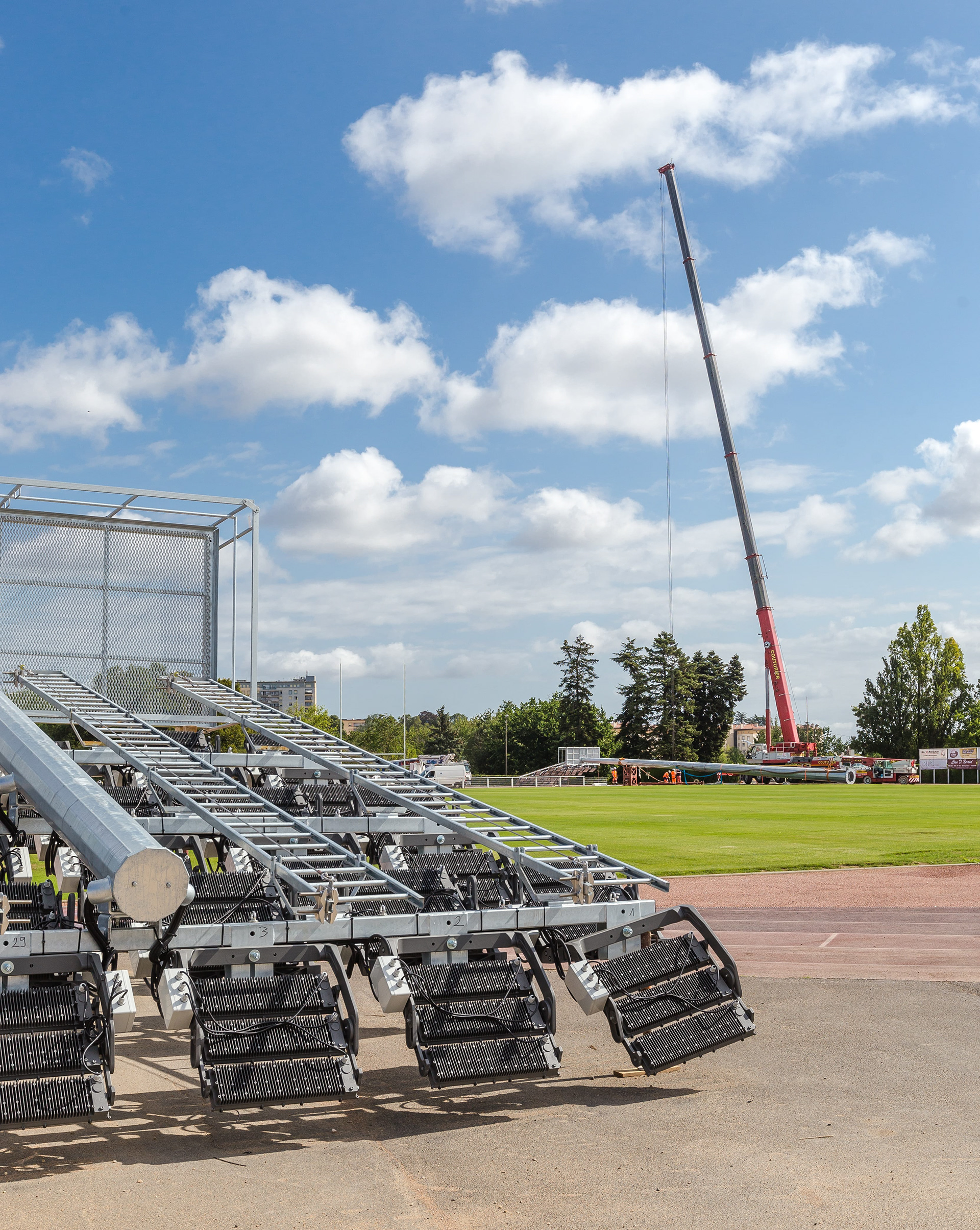 Chantier de construction à Mâcon en Saône-et-Loire, Bourgogne, Rhône-Alpes, avec une grande grue et des équipements industriels sous un ciel bleu parsemé de nuages blancs. Photographie capturée par Etienne Gatheron. Photographie institutionnelle.