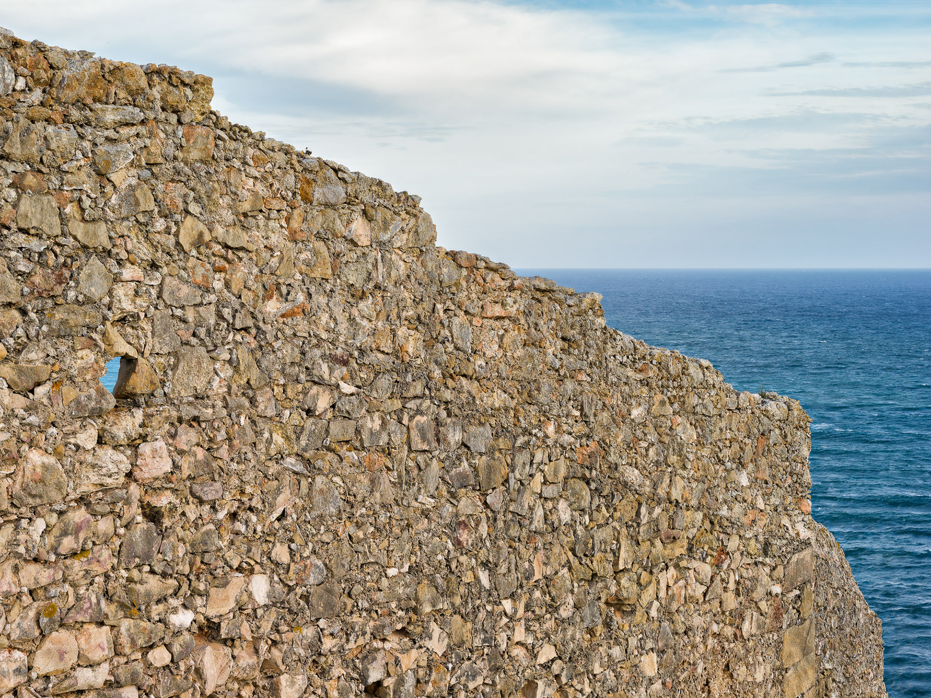 Eine grosse Mauer mit Guckloch mit Meer. © Piero Rossi