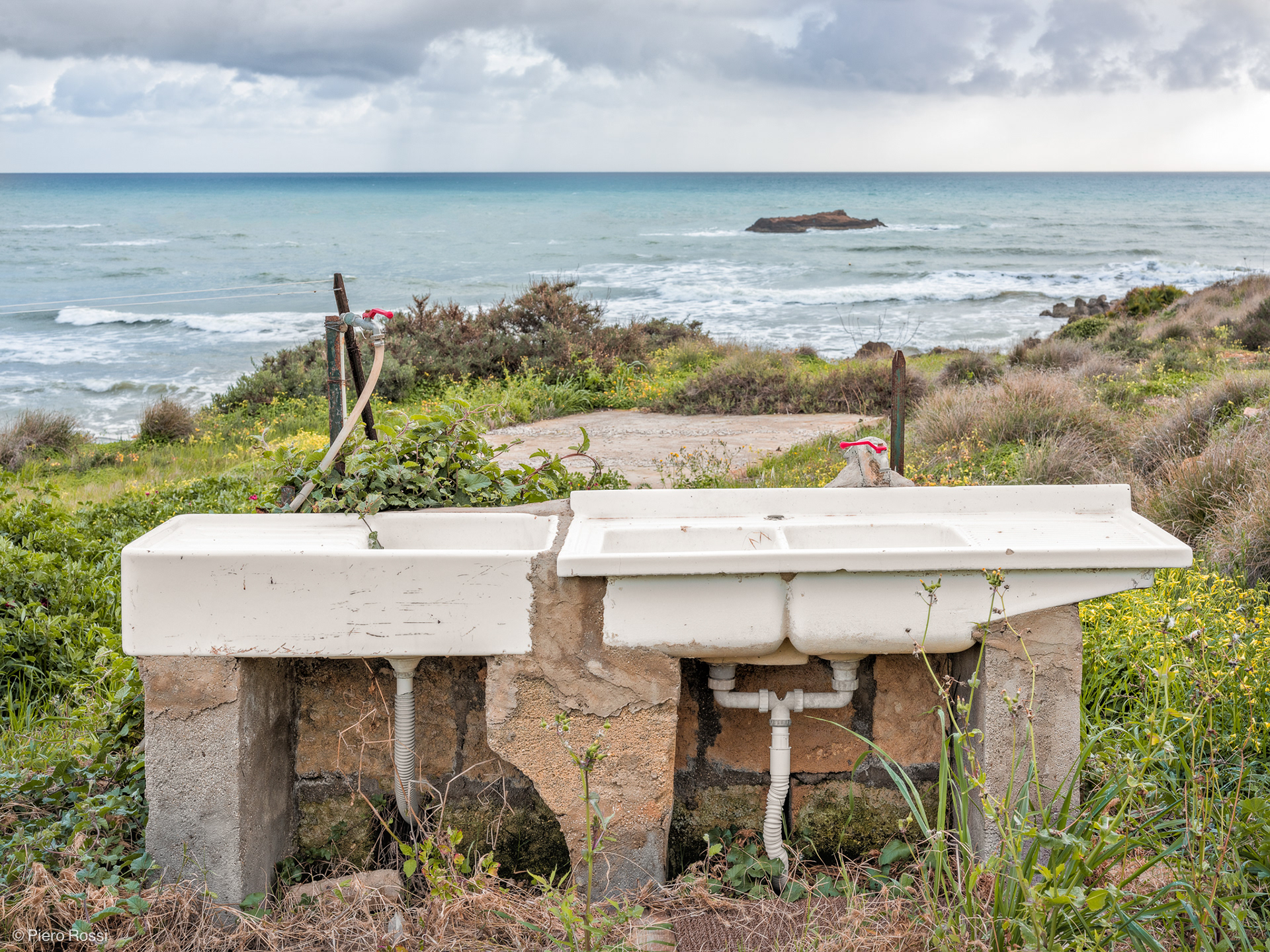 Vorne zwei weisse Spülbecken, dahinter das Meer. © Piero Rossi