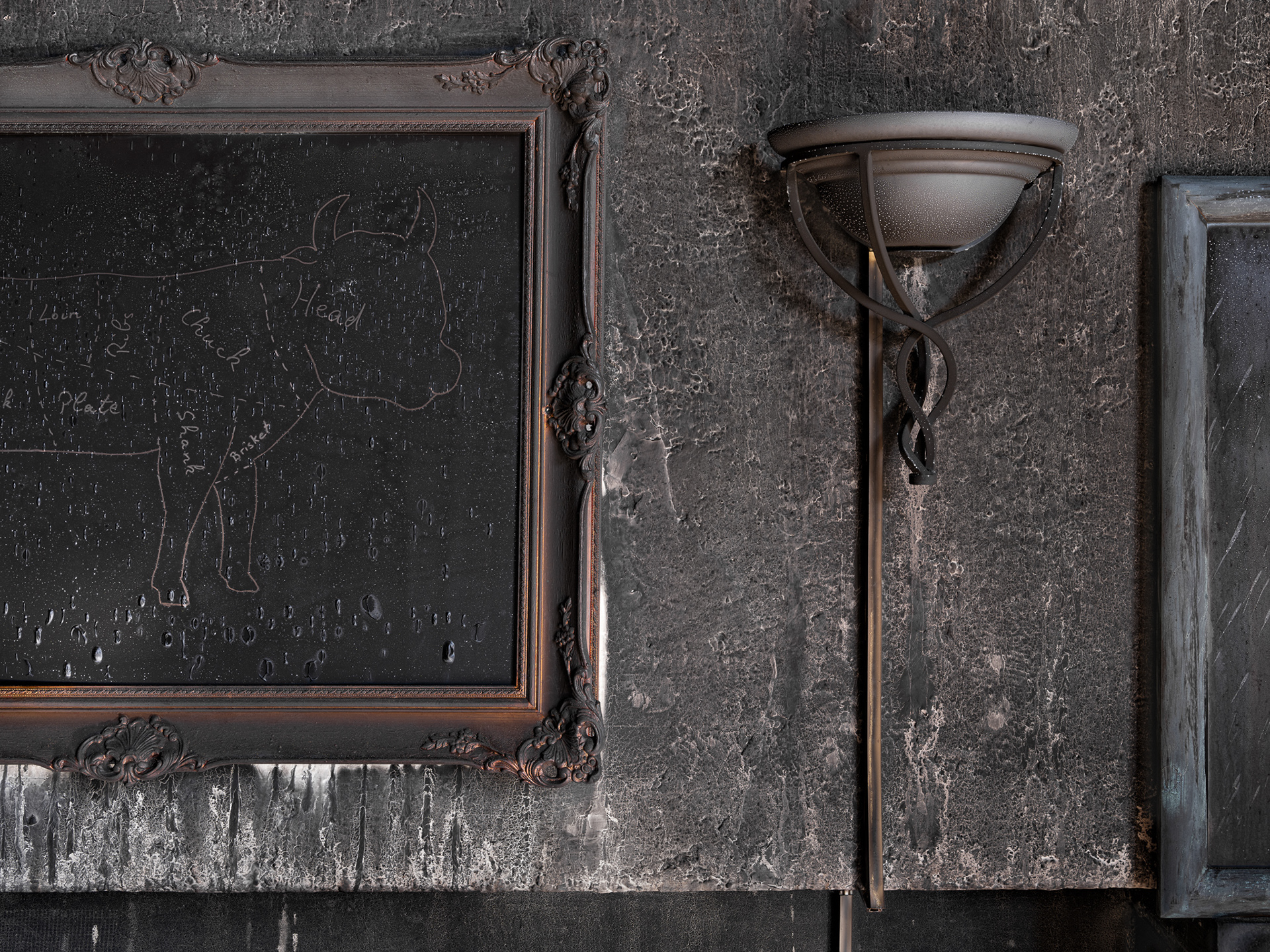 Fotografie einer Mauer mit Bild und Lampe. Alles verkohlt.