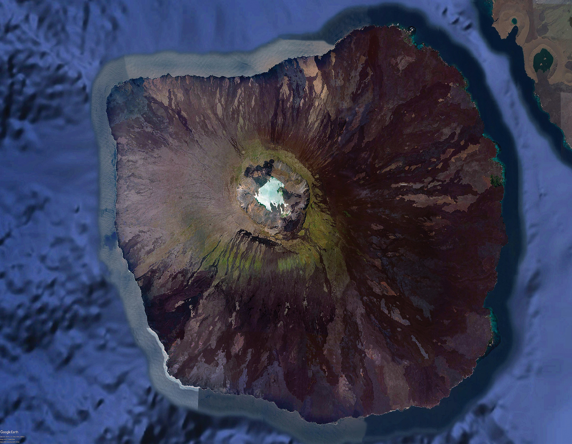 This photo of the island of Fernandina was created in Photoshop using Google Earth imagery, with a special process used to equalize the different patches that result from multiple satellite passes, as well as the presence of clouds, which are notably absent from this photo. This image, along with another set from other islands would be overplayed onto 3D models of the islands to create a lifelike model for VR with pinpoint accuracy. These photos were used as part of an NSF-funded project on Galapagos Volcanoes, as they are one of the few detailed, unobstructed images of the islands.
