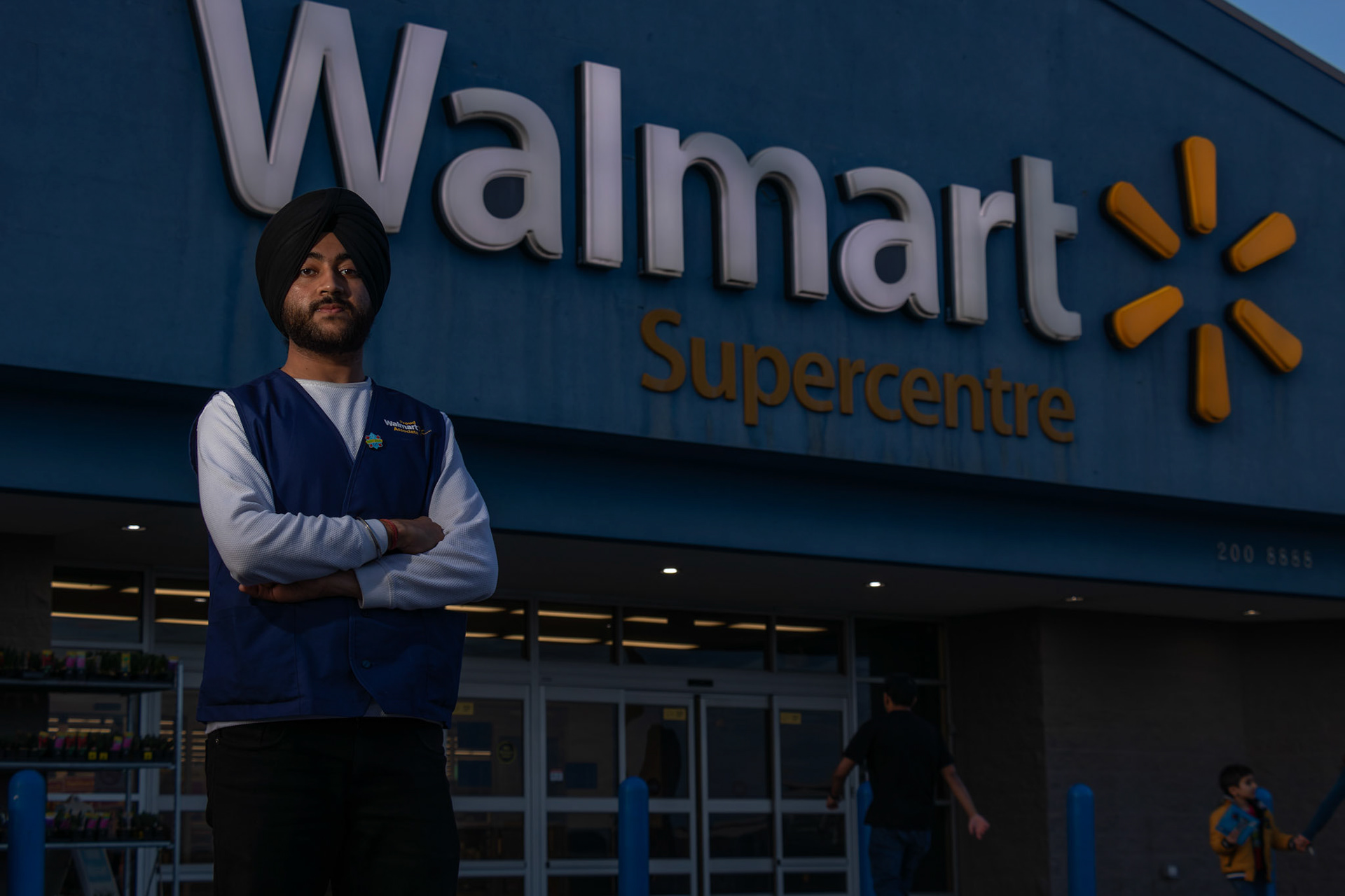 Harmandeep Singh Rathore, a full-time student at SAIT studying ITS and originally from Chandigarh, India, poses for a portrait in front of the Walmart supercenter in Royal Oak NW Calgary on Sunday, April 14, 2024. Harmandeep works part-time as an assistant manager at Walmart to cover his living expenses. (Photo by Armaan Khanna/The Press)