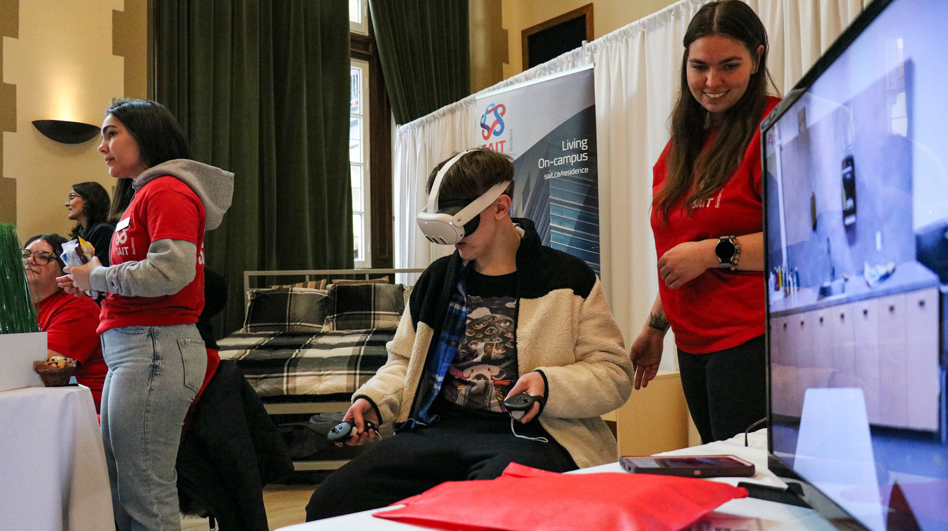Desiree, a SAIT Residence employee, guides a visitor through a residence tour using Virtual Reality as SAIT hosts its Open House event in Calgary on Saturday, March 9, 2024. SAIT Open House is a special event where people can visit, meet teachers and students at SAIT and learn about the college and the programs it offers. (Photo by Armaan Khanna/The Press) Desiree
