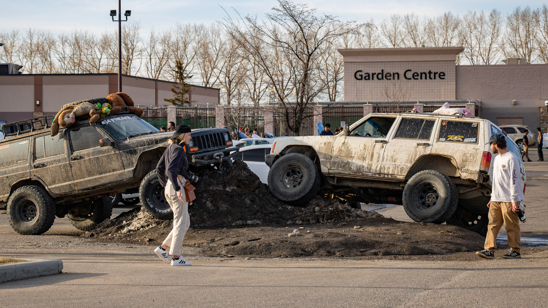 People admire modified jeeps at an unofficial car meet-up in the Royal Oak Shopping Centre parking lot in NW Calgary on Sunday, April 14, 2024. The lot filled up with a variety of modified vehicles displayed by car enthusiasts. The fun ended at sunset when the police showed up. (Photo by Armaan Khanna/The Press)