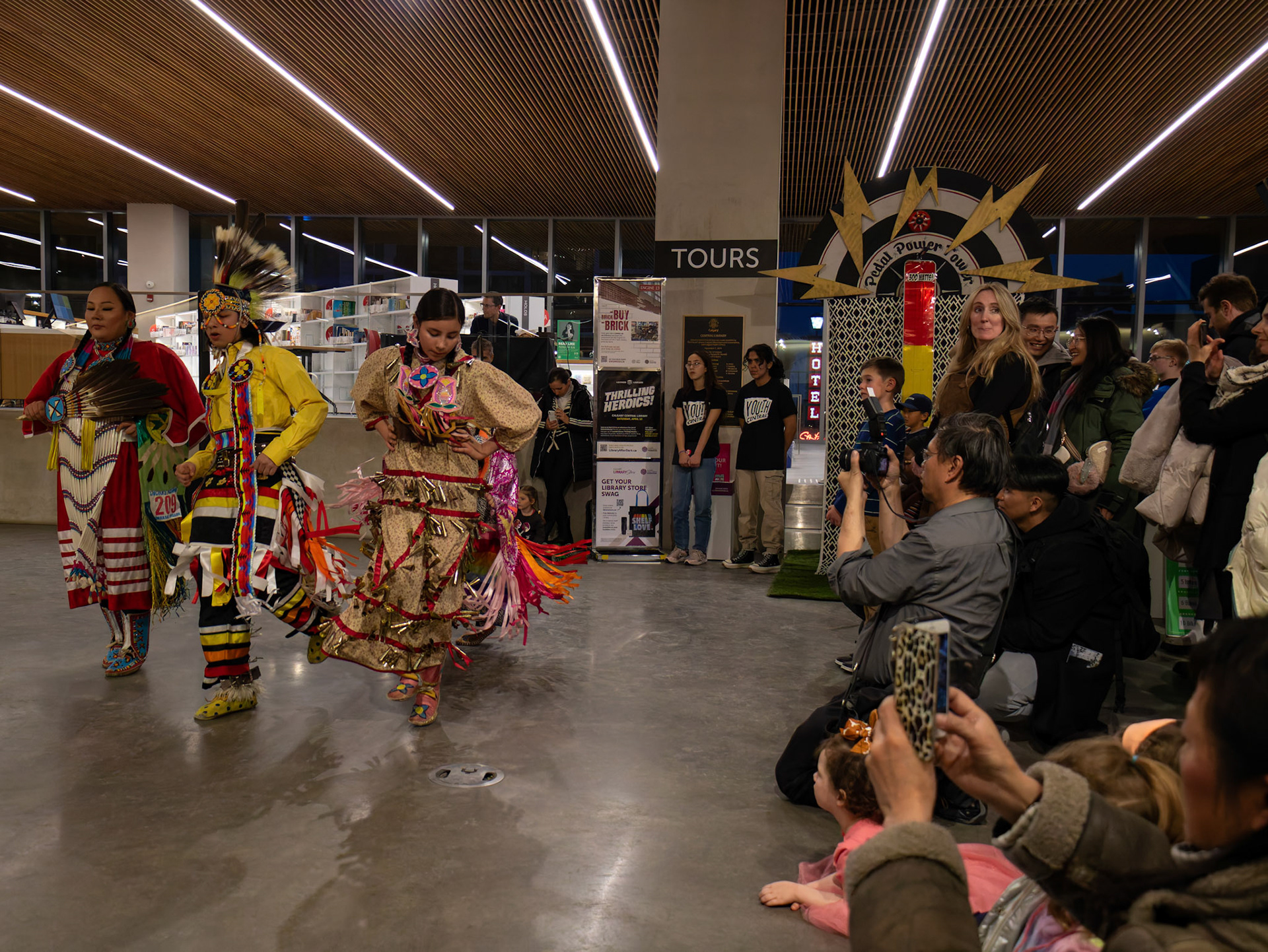 Emily (right), her brother Pehra (middle) and their mother perform a traditional dance at the Earth Day event at Central Library in Calgary on Saturday, March 23, 2024. Calgary's "Unplugged Earth Hour" event offered residents a chance to celebrate sustainability in a lively atmosphere. Partnering with The City of Calgary, The Arusha Centre hosted the event, featuring music, entertainment, and interactive activities. They even encouraged Calgarians to extend their participation by turning off non-essential lights and electronics at home during Earth Hour. (Photo by Armaan Khanna/The Press)