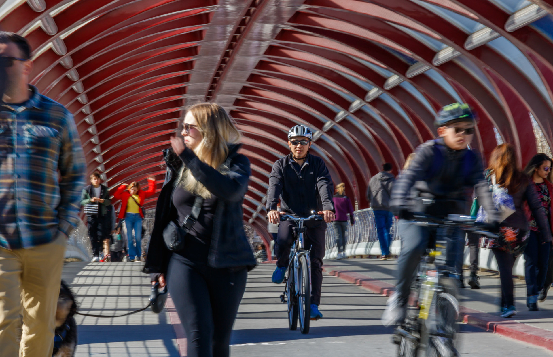 People take advantage of the warm spring weather by cycling and walking across the Peace Bridge in Calgary on Monday, April 1, 2024. With the snow melting away and weather forecasts predicting warmer temperatures this week onwards, Calgarians can expect to see increased activity near the Bow River in the upcoming days, making it a popular destination for recreation. (Photo by Armaan Khanna/The Press)