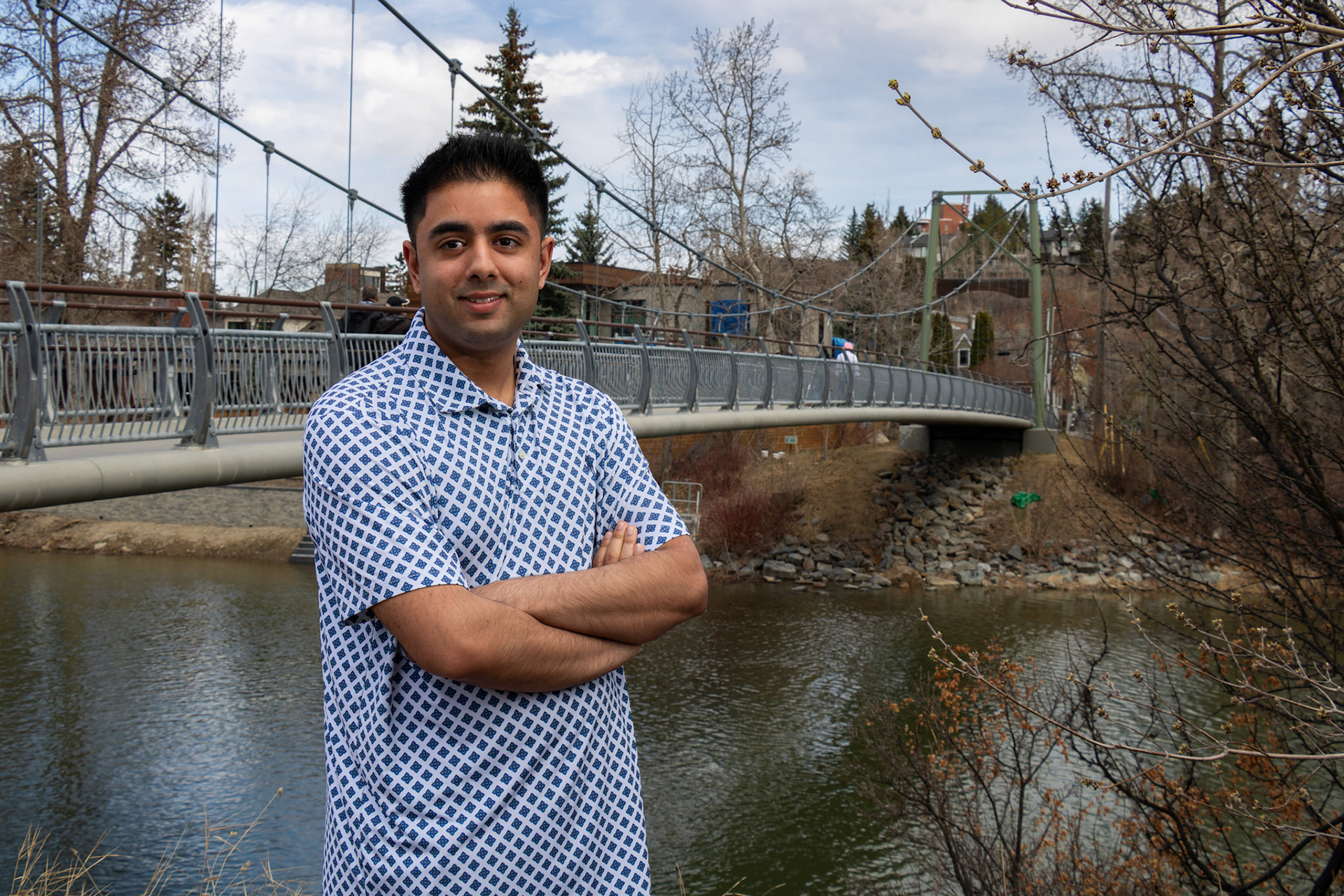 Aleem Awan, a 24-year-old full-time student at SAIT studying print journalism, poses for a portrait in front of the Rideau Bridge above the Elbow River in SW Calgary on Monday, April 15, 2024.  Originally from Saskatoon, Sask., Aleem moved to Calgary, Alta., when he was 7 years old along with his family. Aleem loves walking peaceful trails around his home. This connection with the natural world helps Aleem recharge and gain inspiration for his writing, both for his current studies and for his future dream of becoming a successful blogger.  (Photo by Armaan Khanna/The Press)