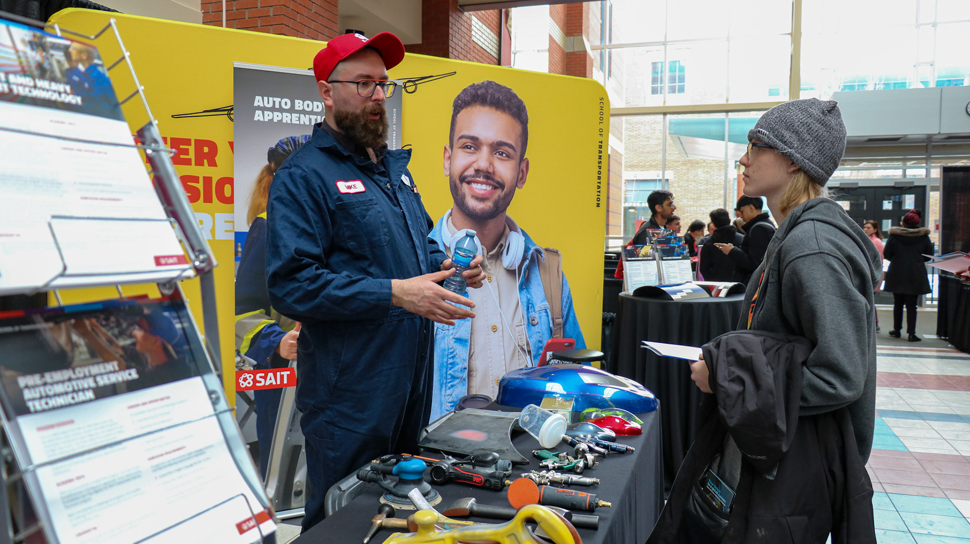 Mike, a SAIT employee, talks to a visitor as SAIT hosts its Open House event in Calgary on Saturday, March 9, 2024. SAIT Open House is a special event where people can visit, meet teachers and students at SAIT and learn about the college and the programs it offers. (Photo by Armaan Khanna/The Press)