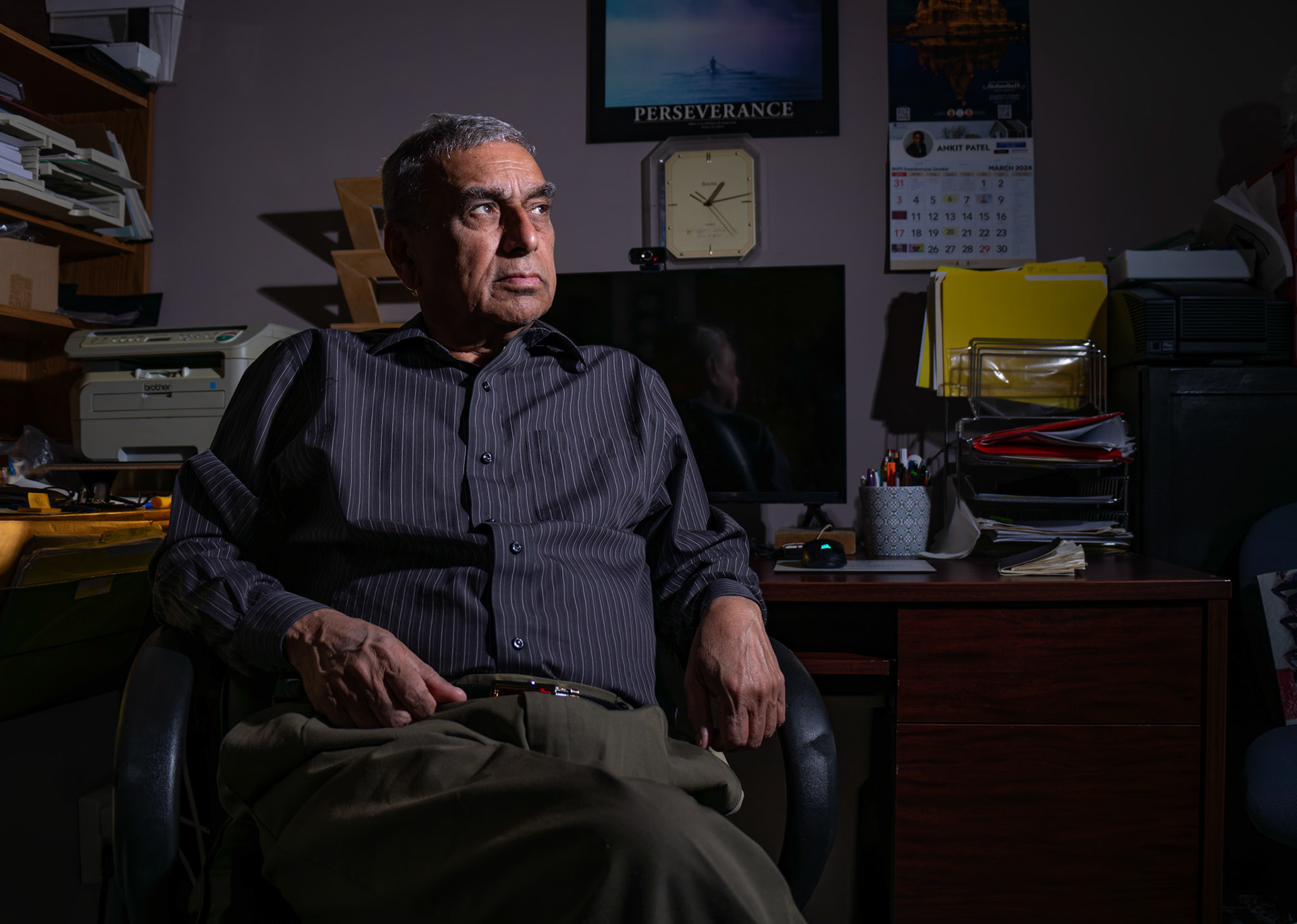 Pravin Tawar, 76, poses for a portrait in his home office in Calgary on Friday, March 29, 2024. Pravin, originally from Ahmedabad, India, moved to Canada with his family in 1972, settling in Regina, Saskatchewan. After 20 years in medical sales, he relocated to Calgary in 1998, where he started an immigration consultancy business. Now, he operates the business from his home office (Photo by Armaan Khanna/SAIT)