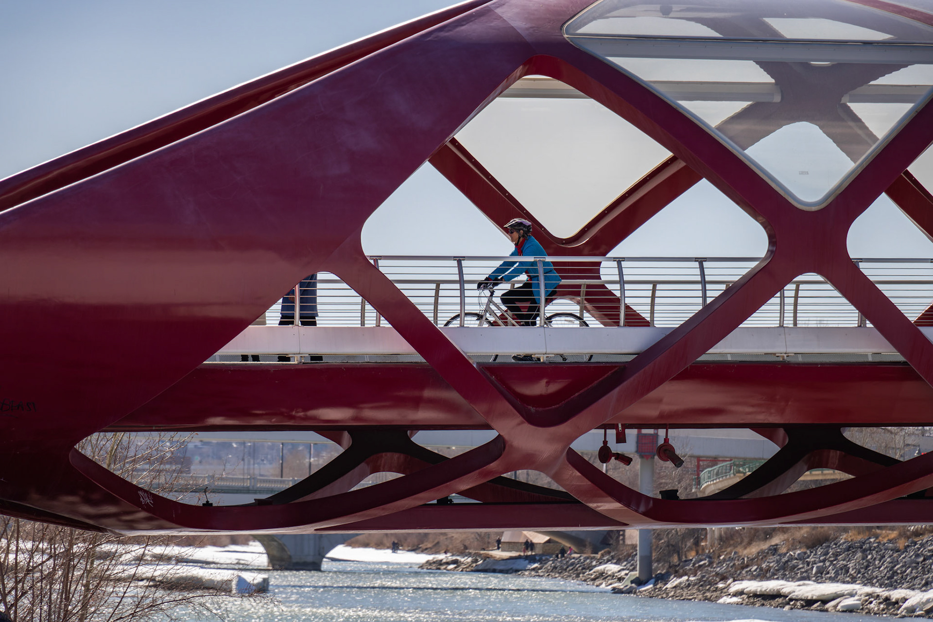A cyclist pedals across the Peace Bridge in Calgary on Monday, April 1, 2024. With the snow melting away and weather forecasts predicting warmer temperatures this week onwards, Calgarians can expect to see increased activity near the Bow River in the upcoming days, making it a popular destination for recreation. (Photo by Armaan Khanna/The Press)