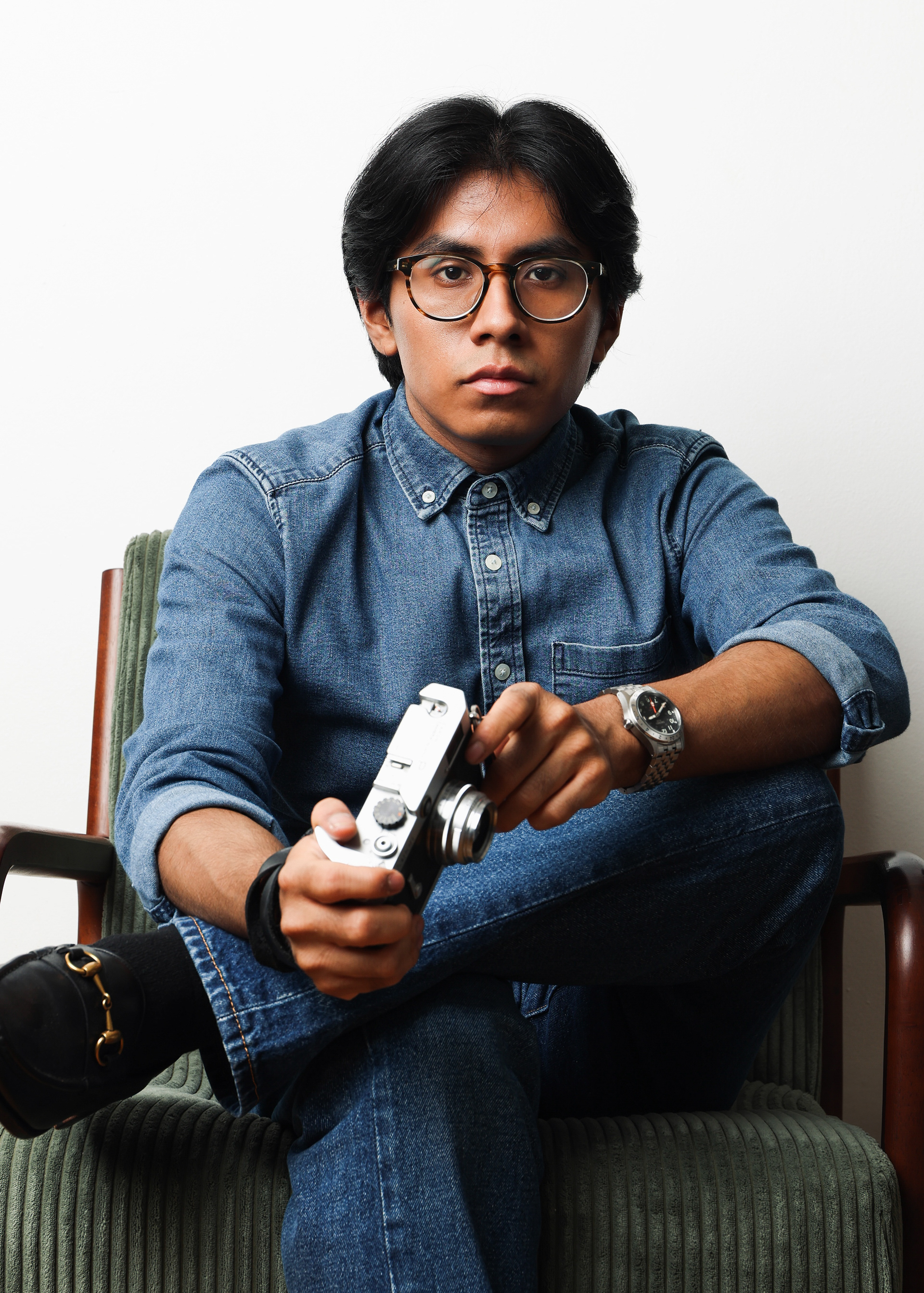 Portrait of Eric Gonzalez in All Denim Outfit holding camera