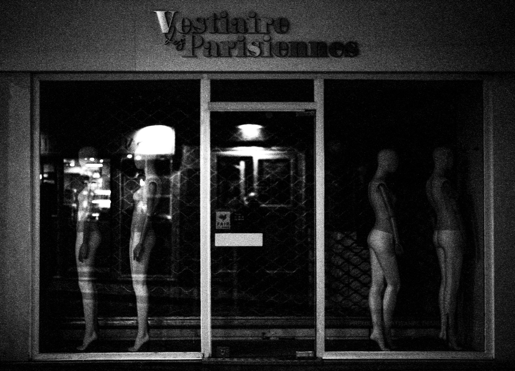 Self-portrait with naked subjects from Paris In the dim reflection of a Parisian storefront, presence and absence intertwine. The mannequins, stripped of their purpose, stand as silent witnesses to the city’s nocturnal stillness. Between them, a faint silhouette —my own— emerges, dissolving into glass and shadow. This photograph is a meditation on exposure, anonymity, and the fragile line between the observer and the observed.