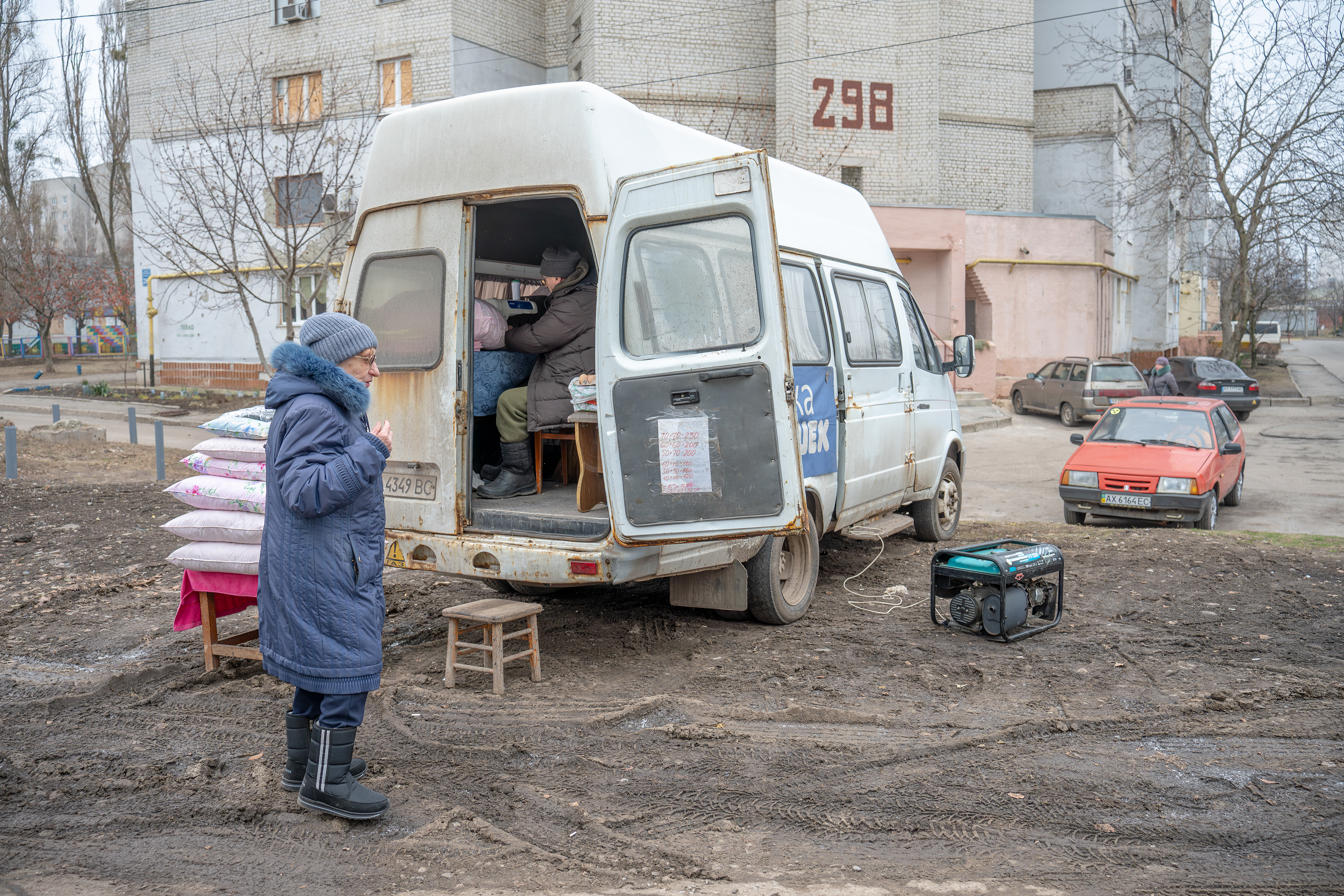 A man has set up his mobile tailoring shop inside a van, powered by a diesel generator. He regularly visits Kharkiv's Industrialna district to offer his services. 