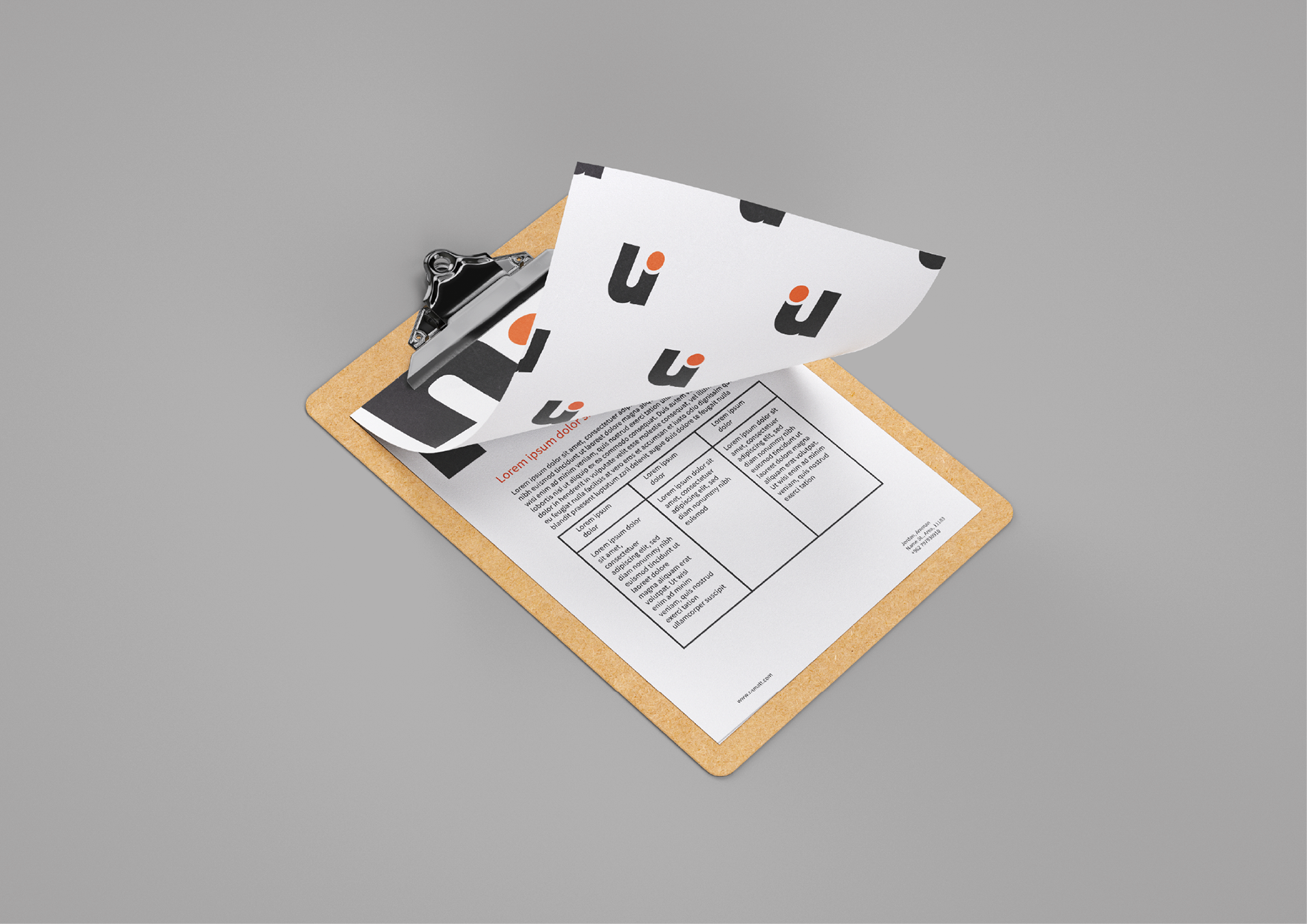 NAMATT stationery mockup showing a printed form on a clipboard beneath a sheet patterned with black and orange brand symbols.