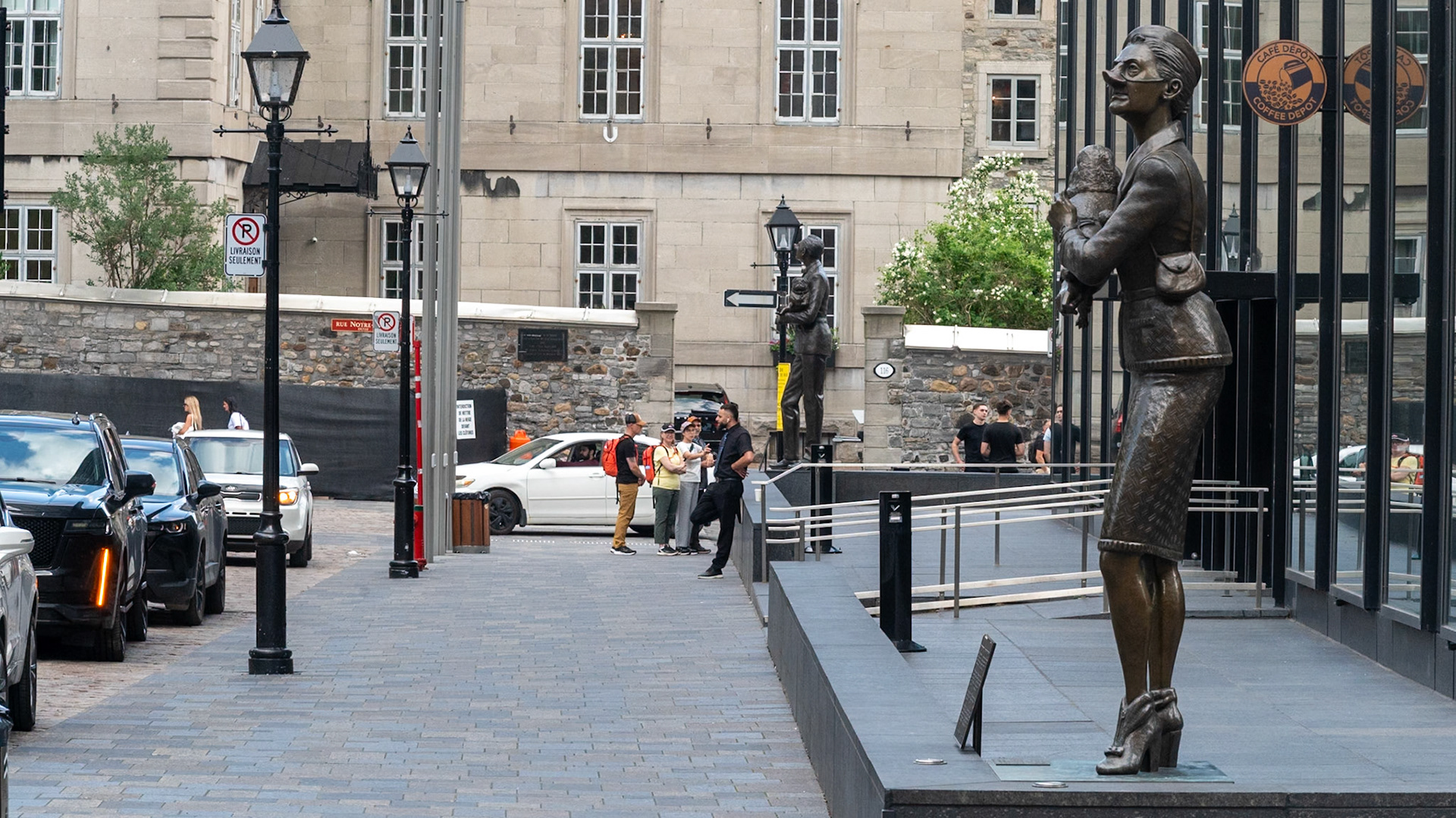 The English Pug and the French Poodle:An English man holding a pug is giving a superior stare at the basilica, a symbol of the religions influence on French CanadiansA French woman holding a poodle shoots an offended look at the Bank of Montreal head office, a symbol of English power.With their masters oblivious, the two dogs are focused on each other.