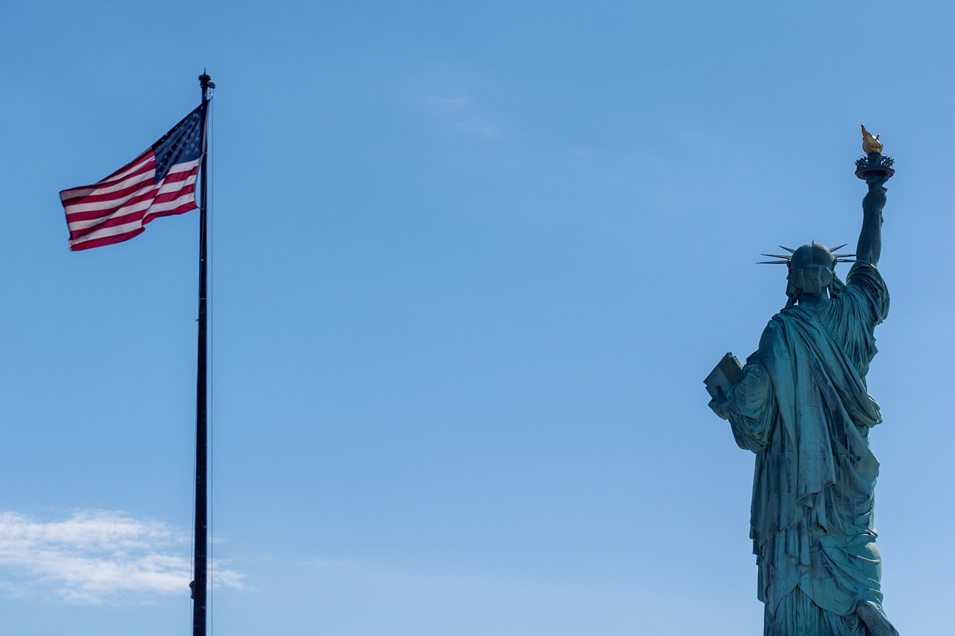 Slight illusion:  The flag is actually behind the Statue of Liberty