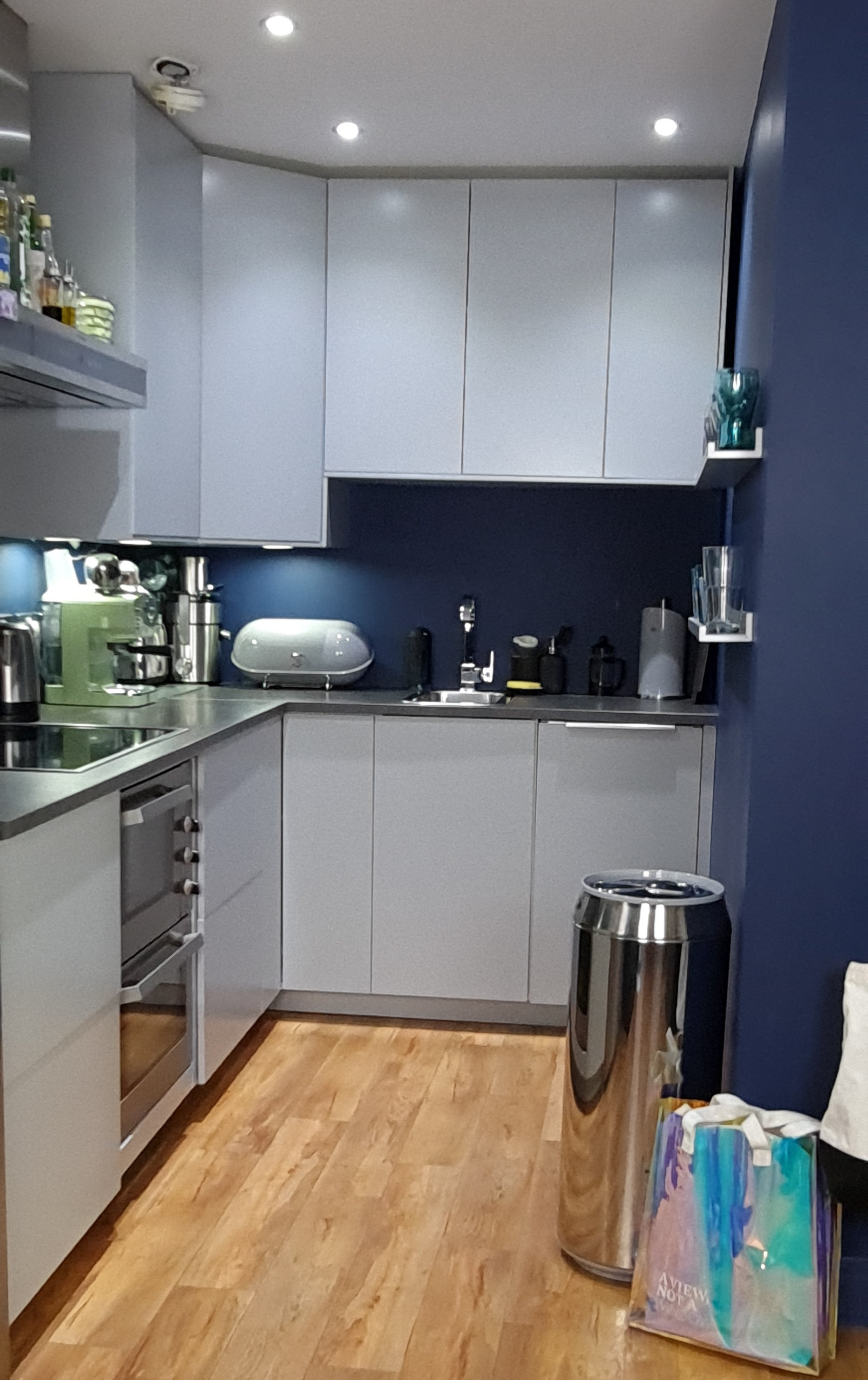According to the dark colour scheme in the kitchen area, the kitchen fronts are in a light grey with a matte finish. The handleless doors and drawer components enhance the sleek modern appearance. It was essential to increase the amount of storage, which led to the preference to install high wall units up to the ceiling.