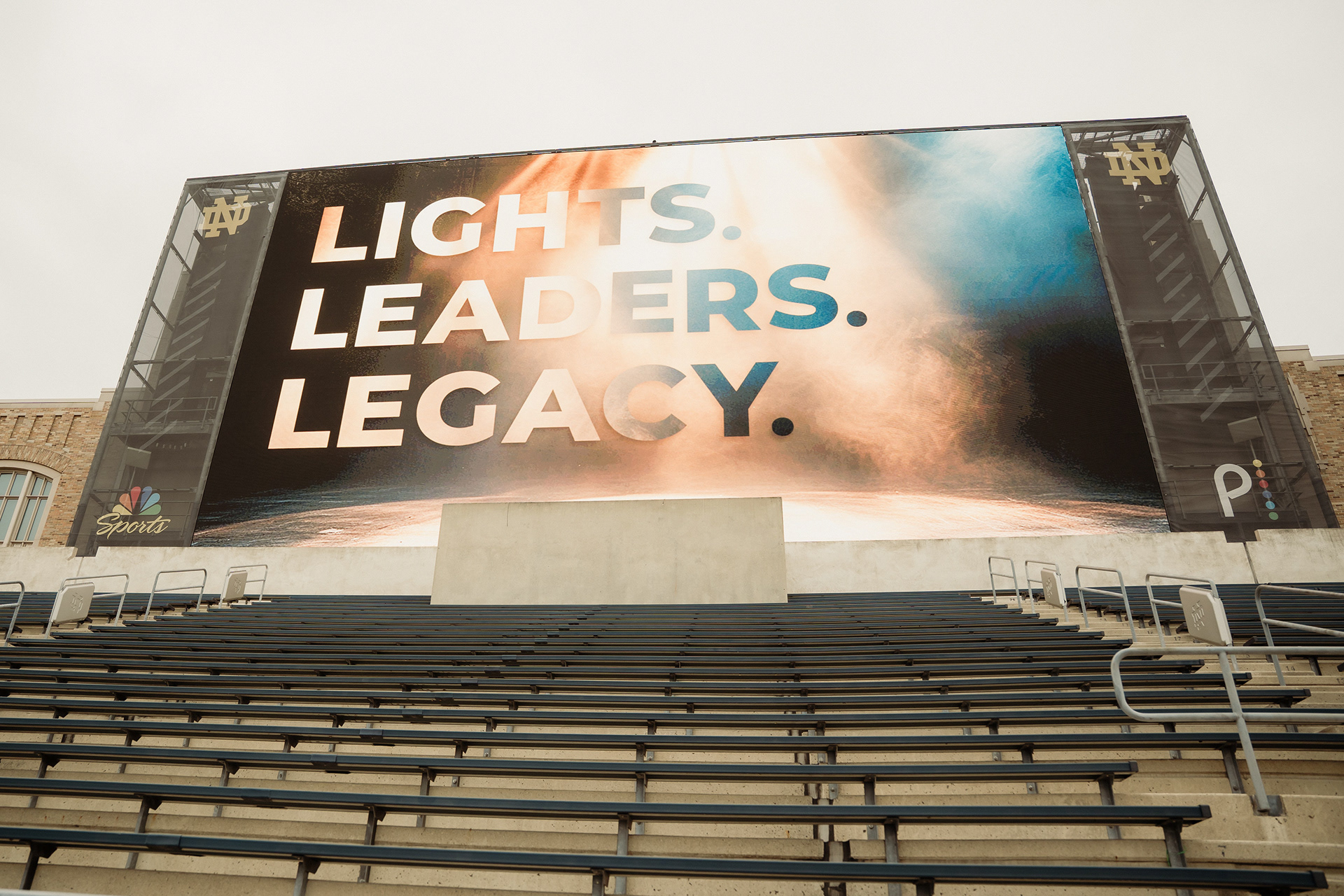 Lights. Leaders. Legacy. Art displayed on the football field jumbotron.