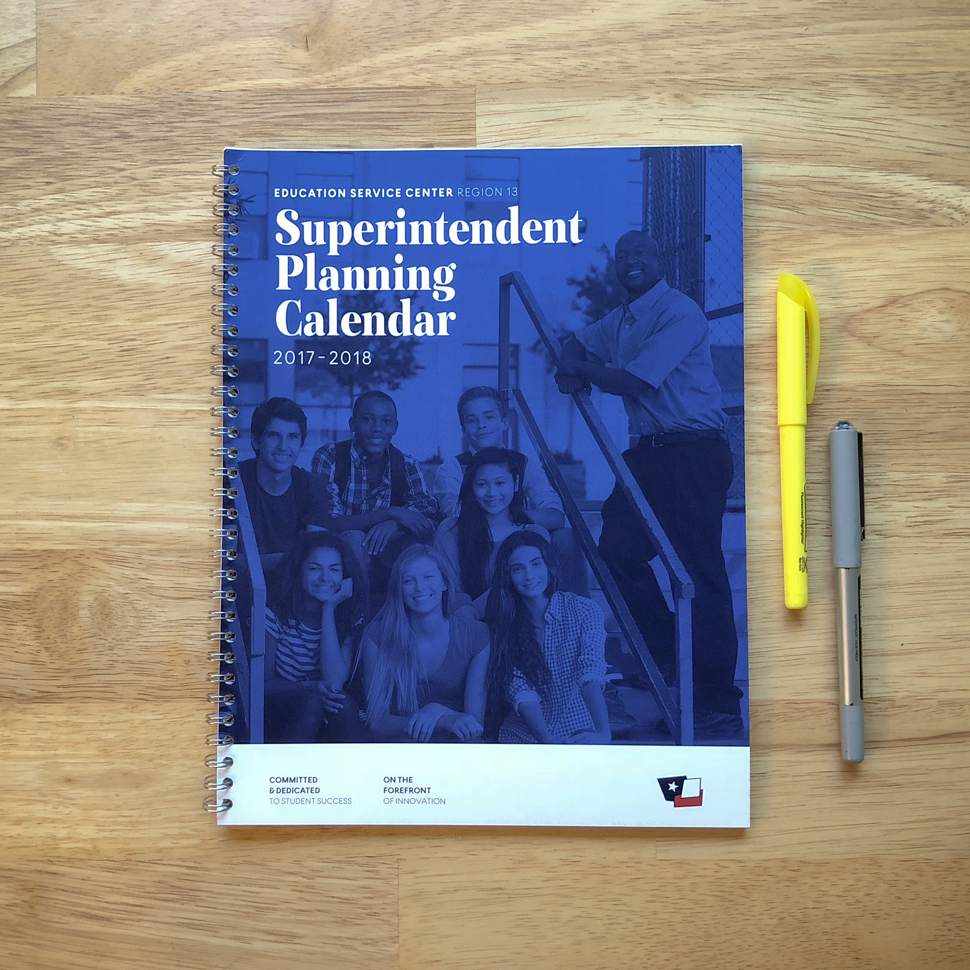 A branded, printed, and wire-bound academic planning calendar– featuring an educator and students on the cover.
