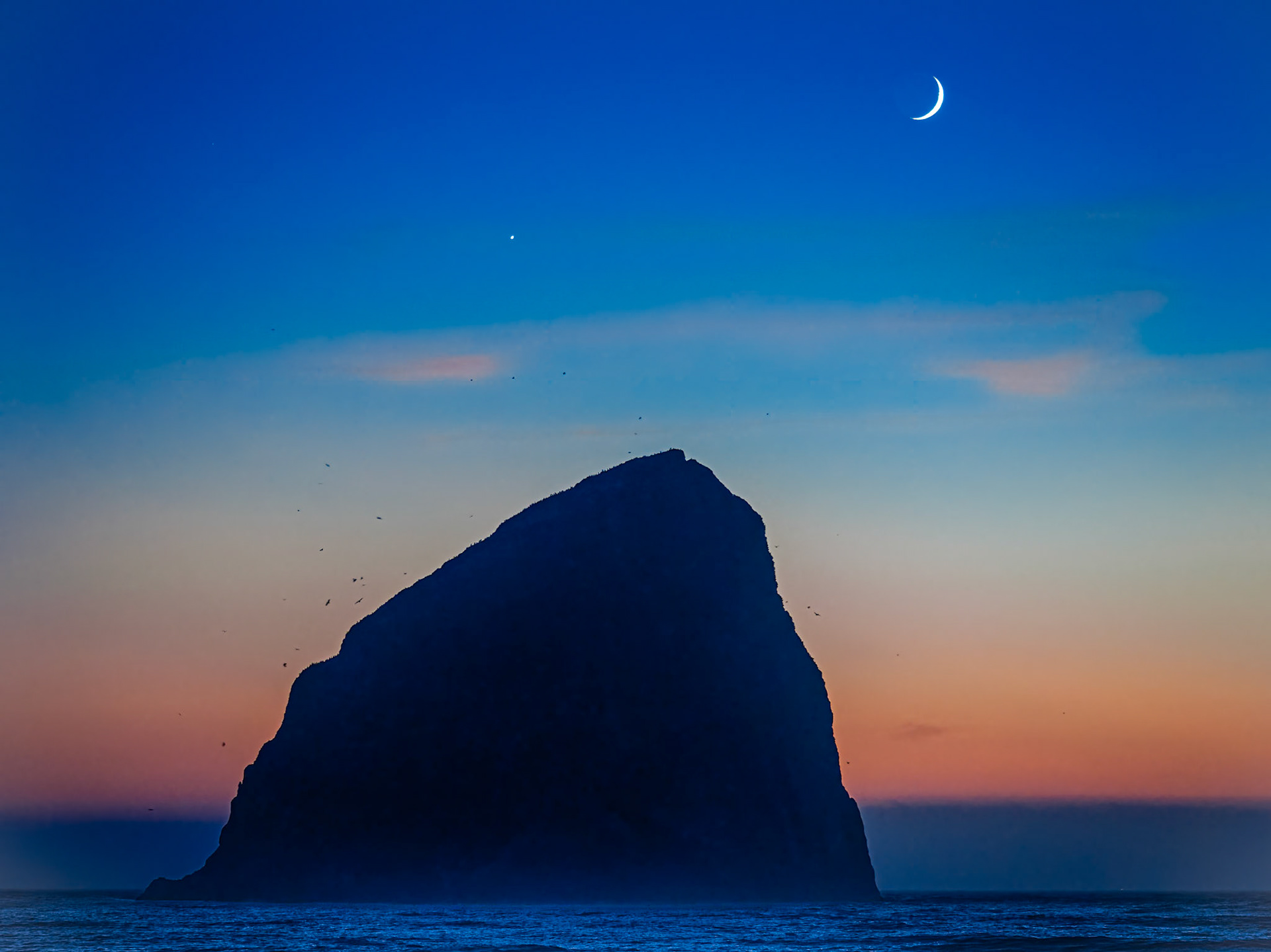 Chief Kiwanda Rock Under Venus and a Crescent Moon - Landscape: The crescent moon and Venus setting behind Chief Kiwanda Rock in the blue hour after sunset in Pacific City Oregon.