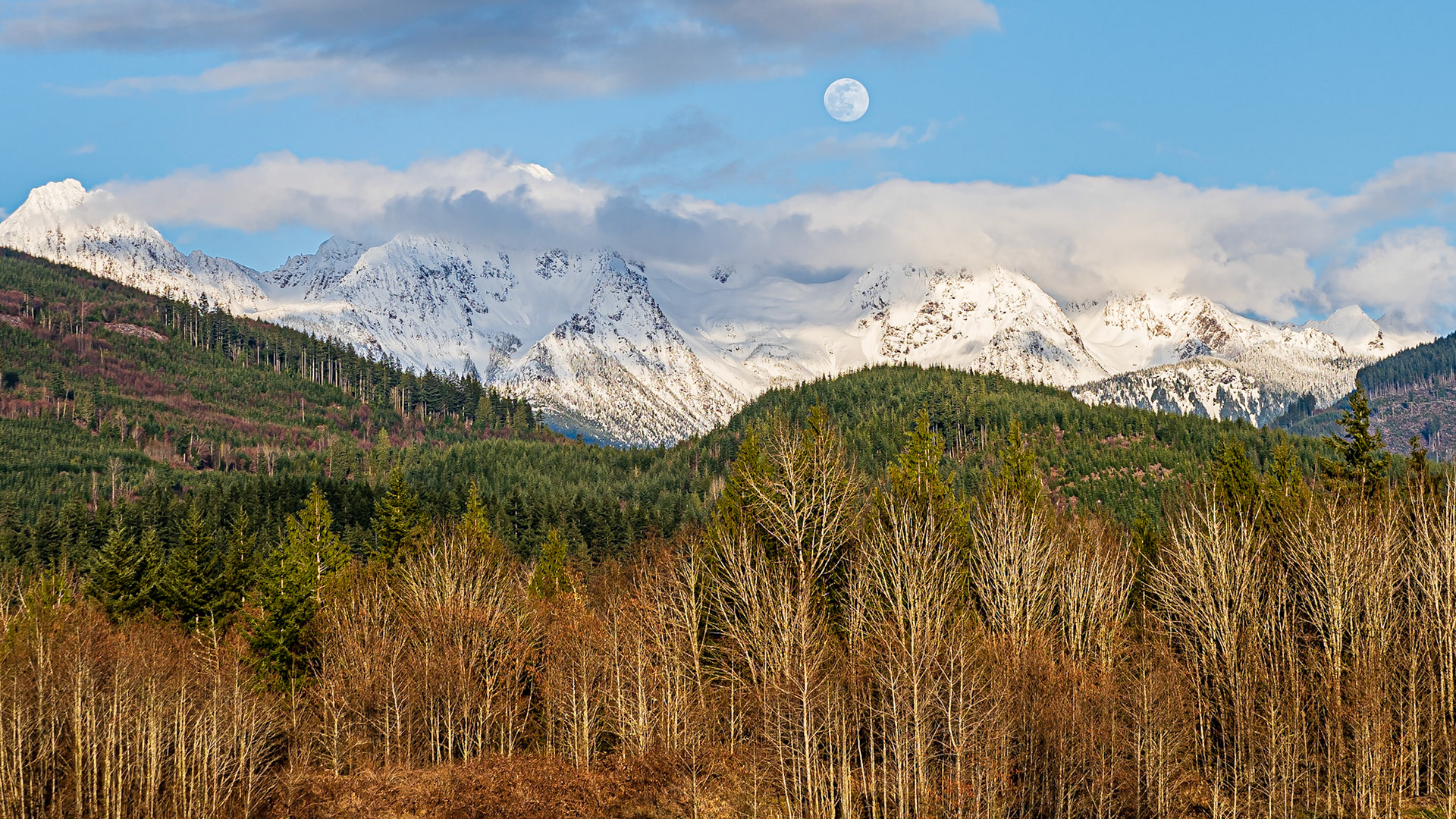 Twin Peaks Moonrise Panorama 1: The clouds parted on an overcast day to reveal the moon rising above Twin Peaks near Mt. Baker in the Washington Cascades