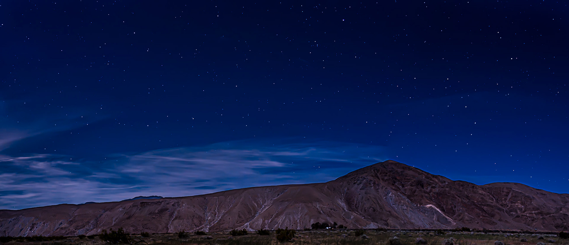 Moon Light on Coyote Mountain: A waxing gibbous moon gives faint illumination to Coyote Mountain and a desert homestead nestled in a copse of trees near the entrance to Coyote Canyon in the Anza-Borrego Desert State Park.