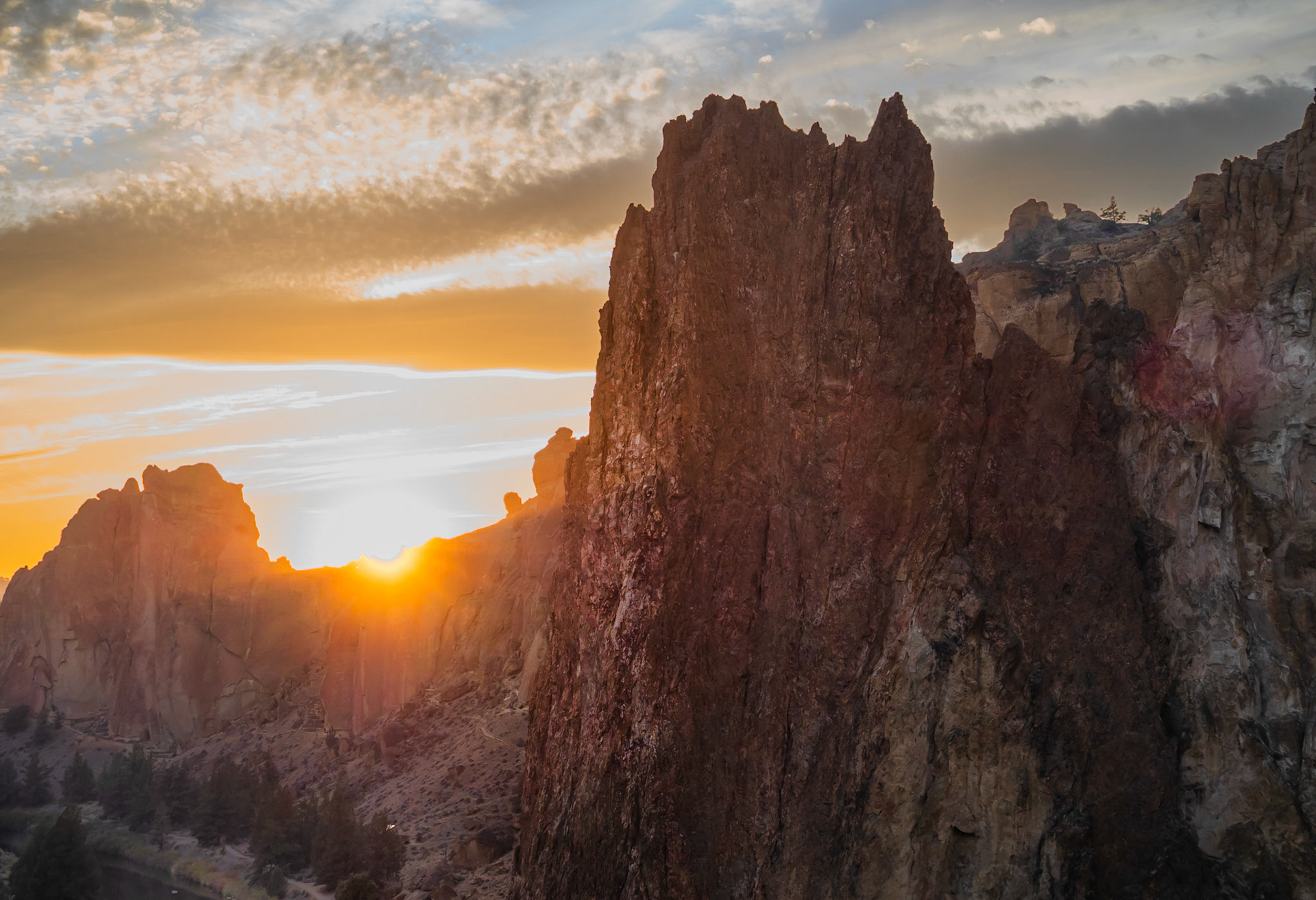 Last Rays at Smith Rock: The last few rays of sunset spill over a craggy ridge onto Crooked River and the face of Smith Rock in Oregon's high desert.