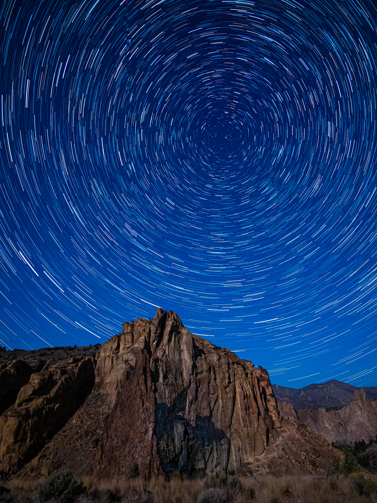 Smith Rock Star Trails: A gibbous moon provided faint light to illuminate Smith Rock at night.  A long exposure sequence captured Polaris and star trails rotating above the peak.