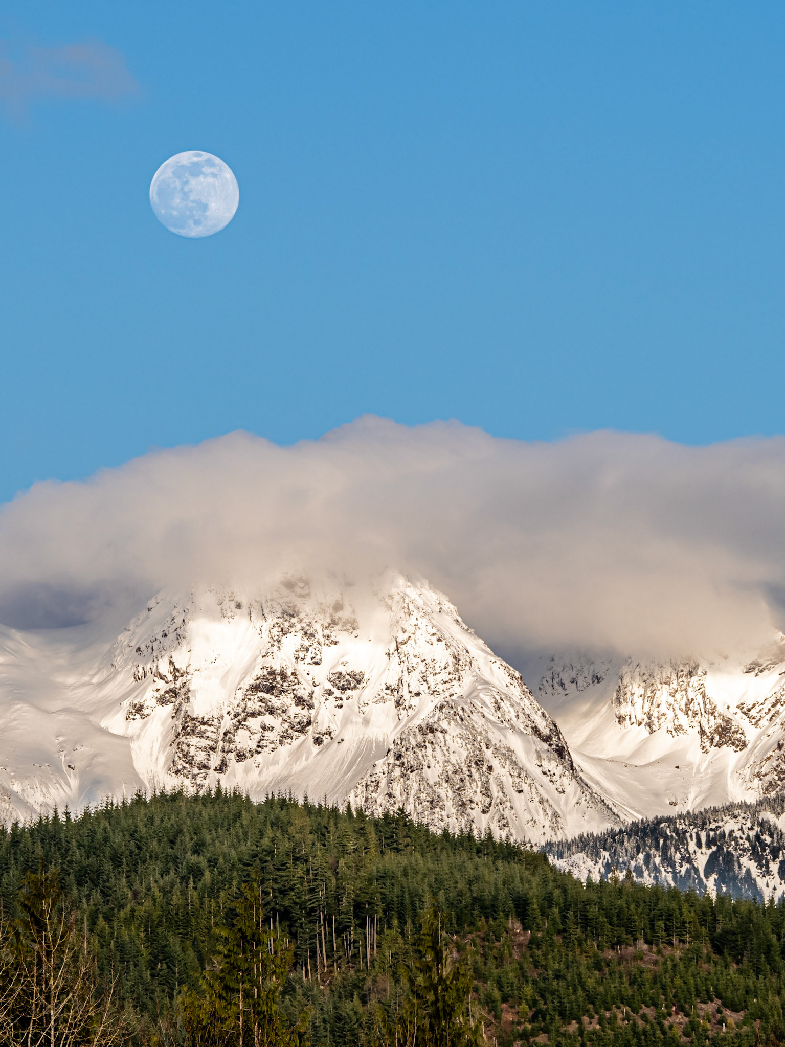 Twin Peaks Moonrise 2: The clouds parted on an overcast day to reveal the moon rising above Twin Peaks near Mt. Baker in the Washington Cascades