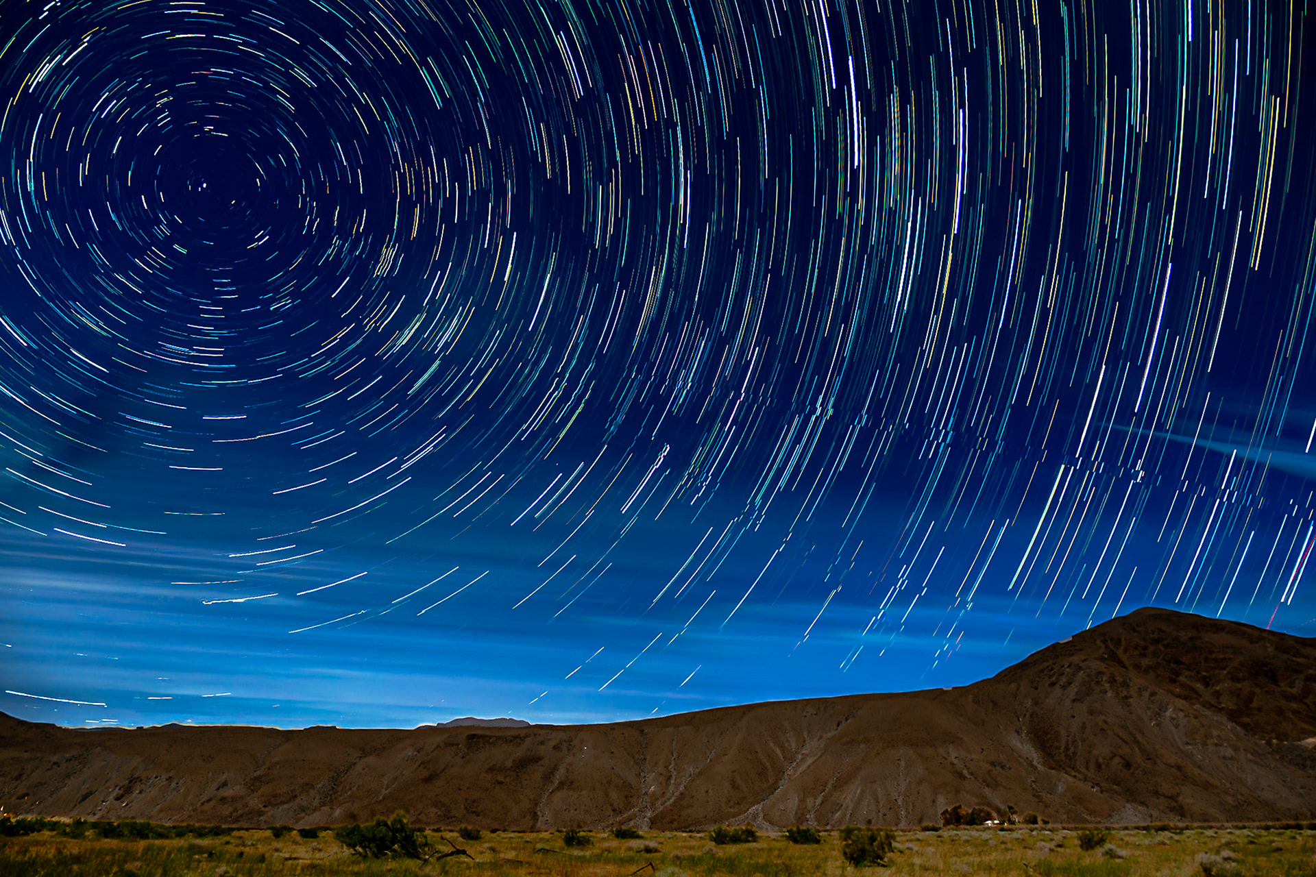 Borrego Valley Startrails: Star trails swirl over a solitary Borrego-Valley farmhouse seen at the foot of Coyote Peak on a soft moonlit night.