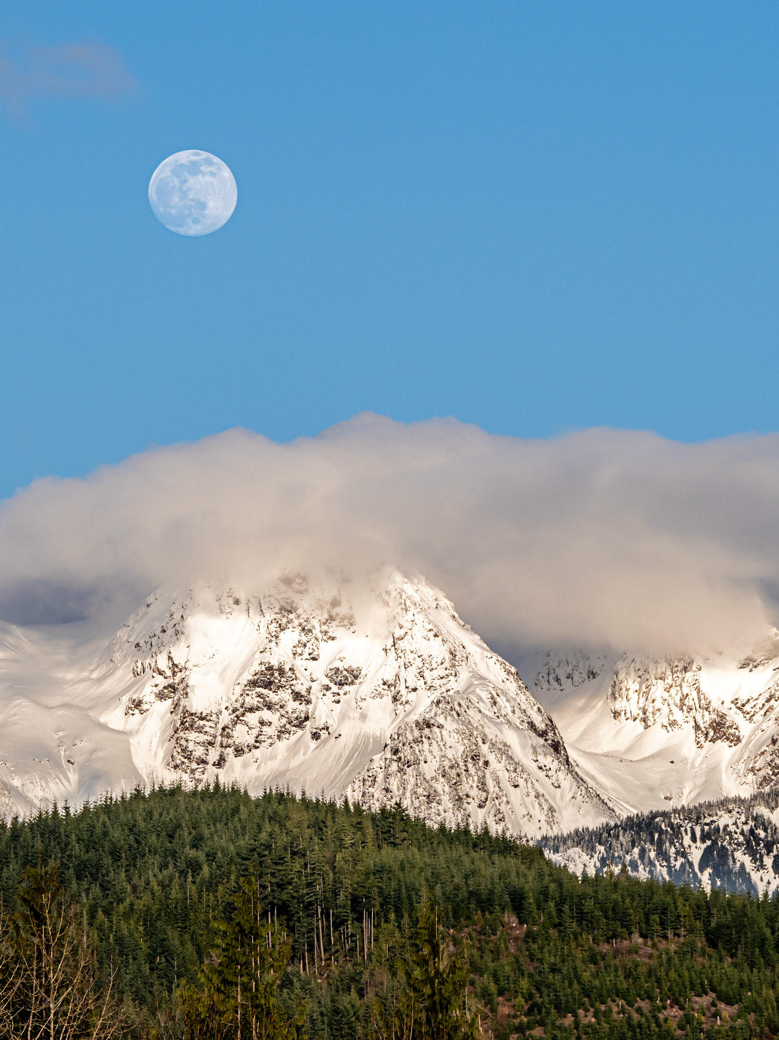 Cascade Moon: The moon rising in the evening hour above Twin Peaks near Mt. Baker in the Washington Cascades.