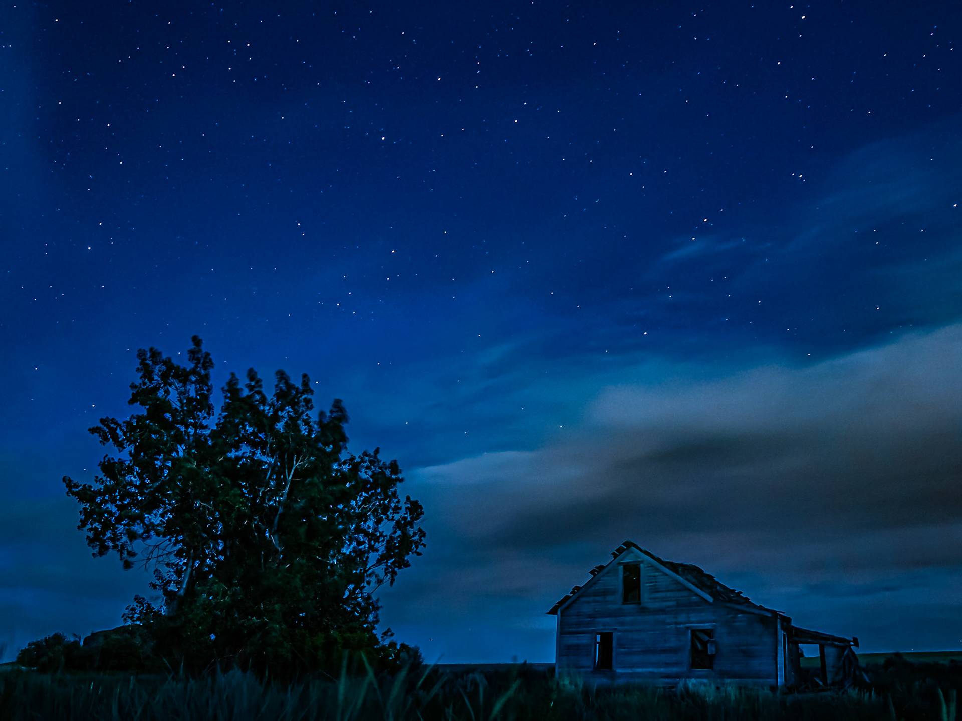 Abandoned Homestead at Night: An old homestead sits under evening stars and clouds where it watches over the Waterville Plateau near Dyer Washington.