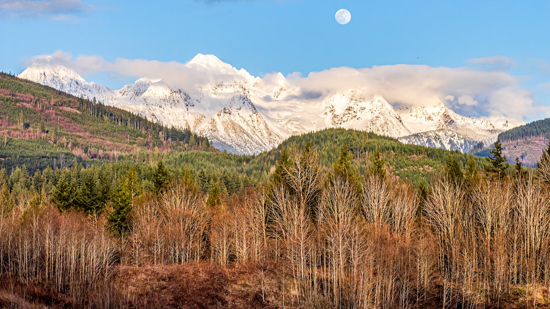 Cascade Moonrise Panorama: The clouds parted on an overcast day to reveal the moon rising above Twin Peaks near Mt. Baker in the Washington Cascades
